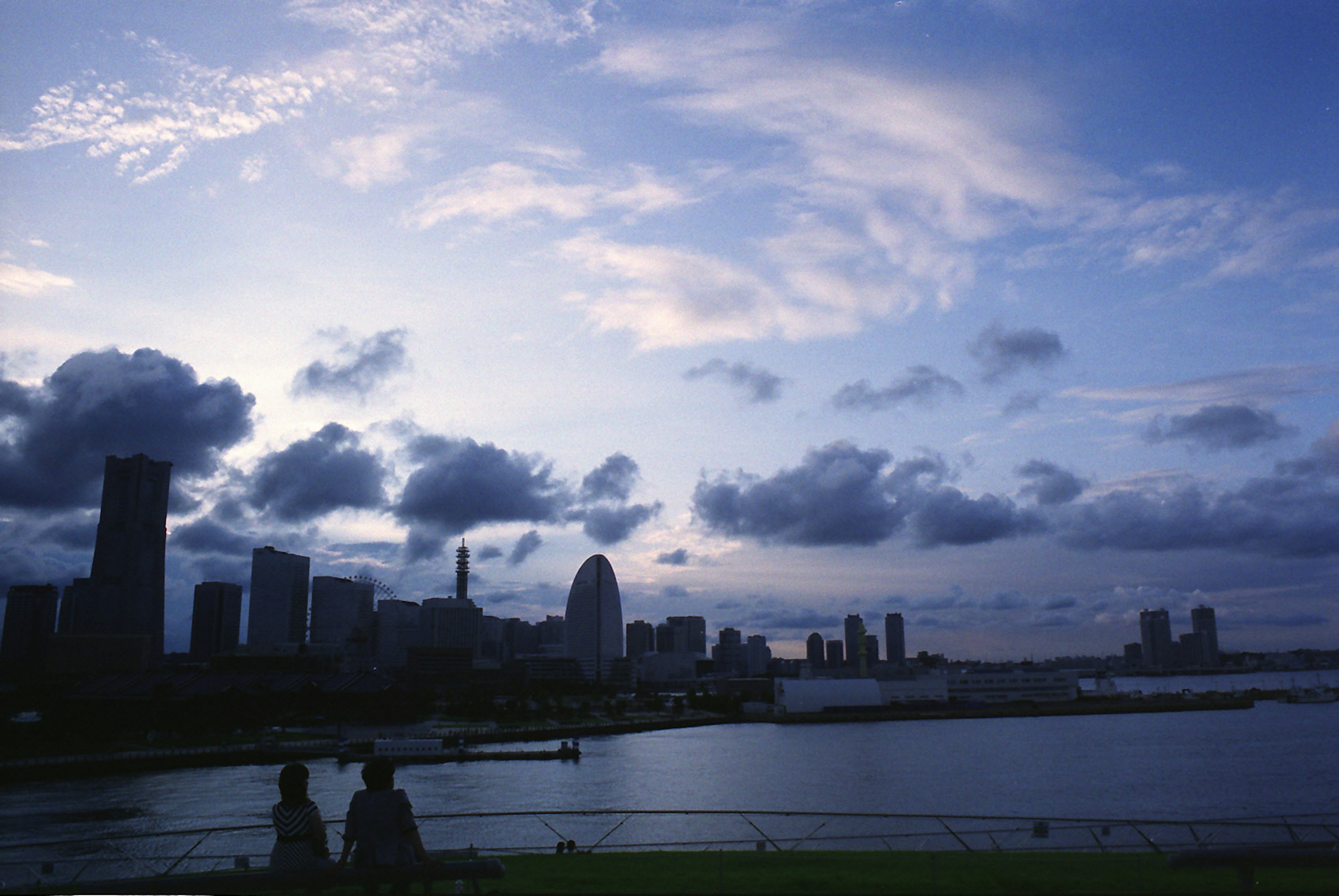 Silhouette of a city skyline at dusk with water reflections