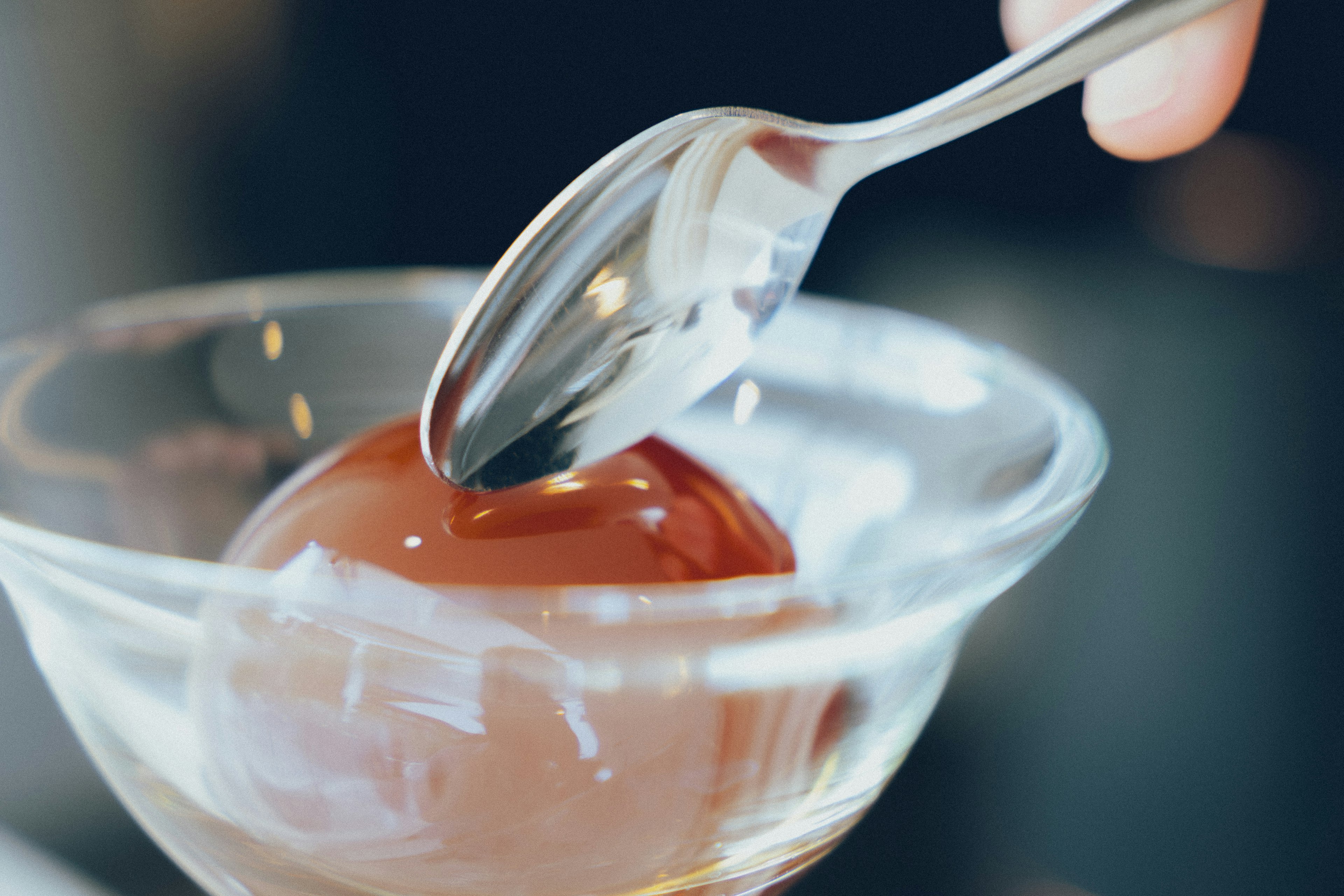 Close-up of a hand using a spoon to scoop chocolate dessert