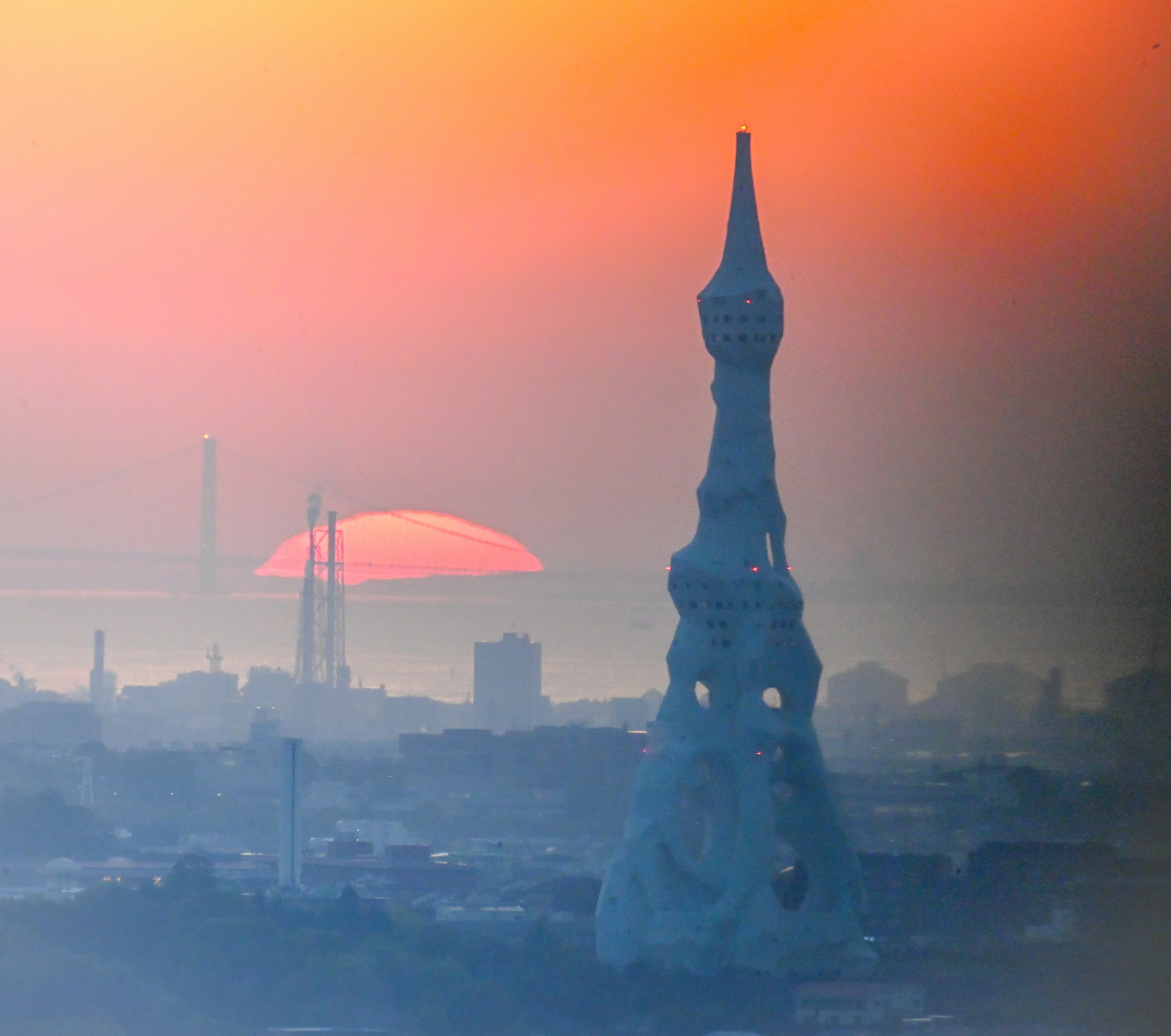 Silhouette of a unique tower against a sunset backdrop