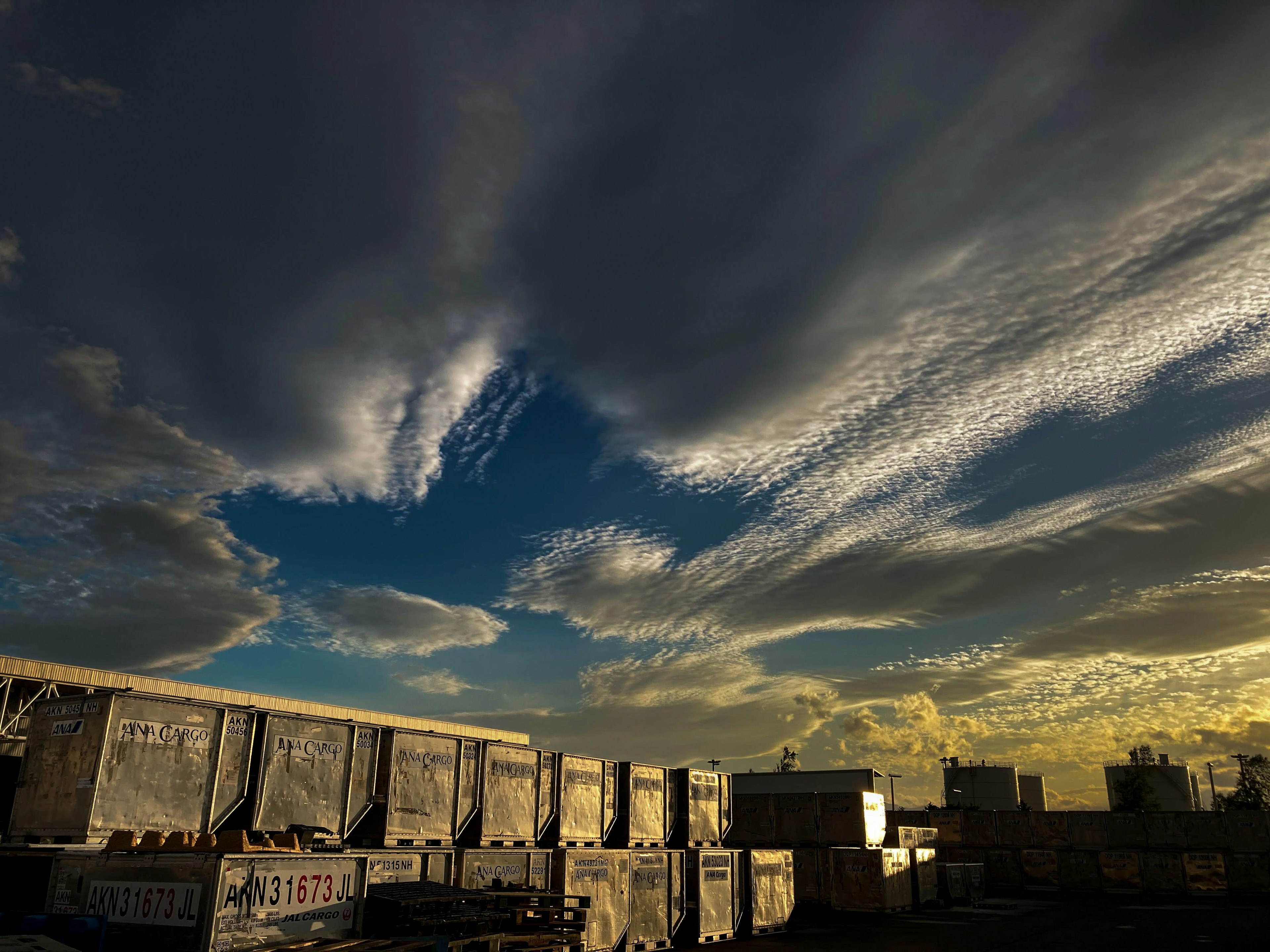 Cielo vasto con nubes dramáticas y tonos azules que presentan luz dorada cerca del horizonte