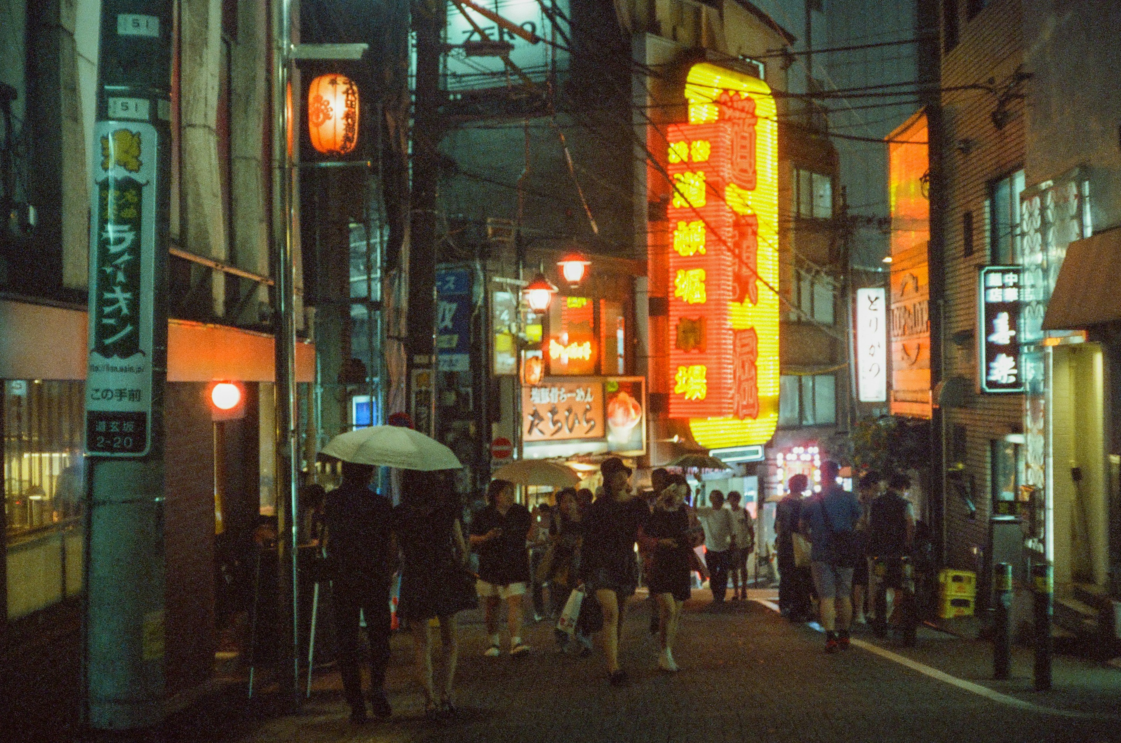 夜の街並みに賑わう人々とネオンの看板