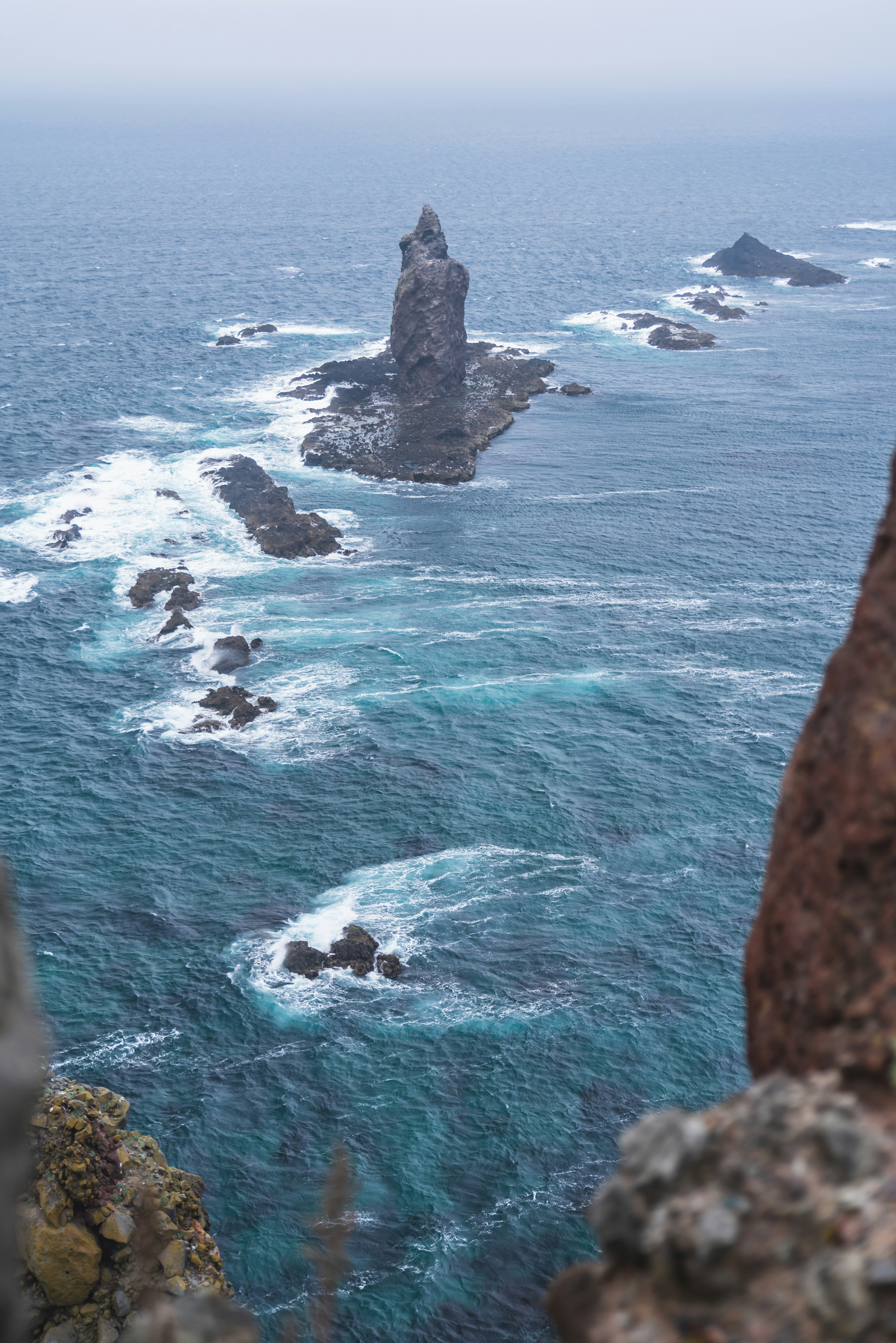 Faro en una isla rocosa con mar agitado