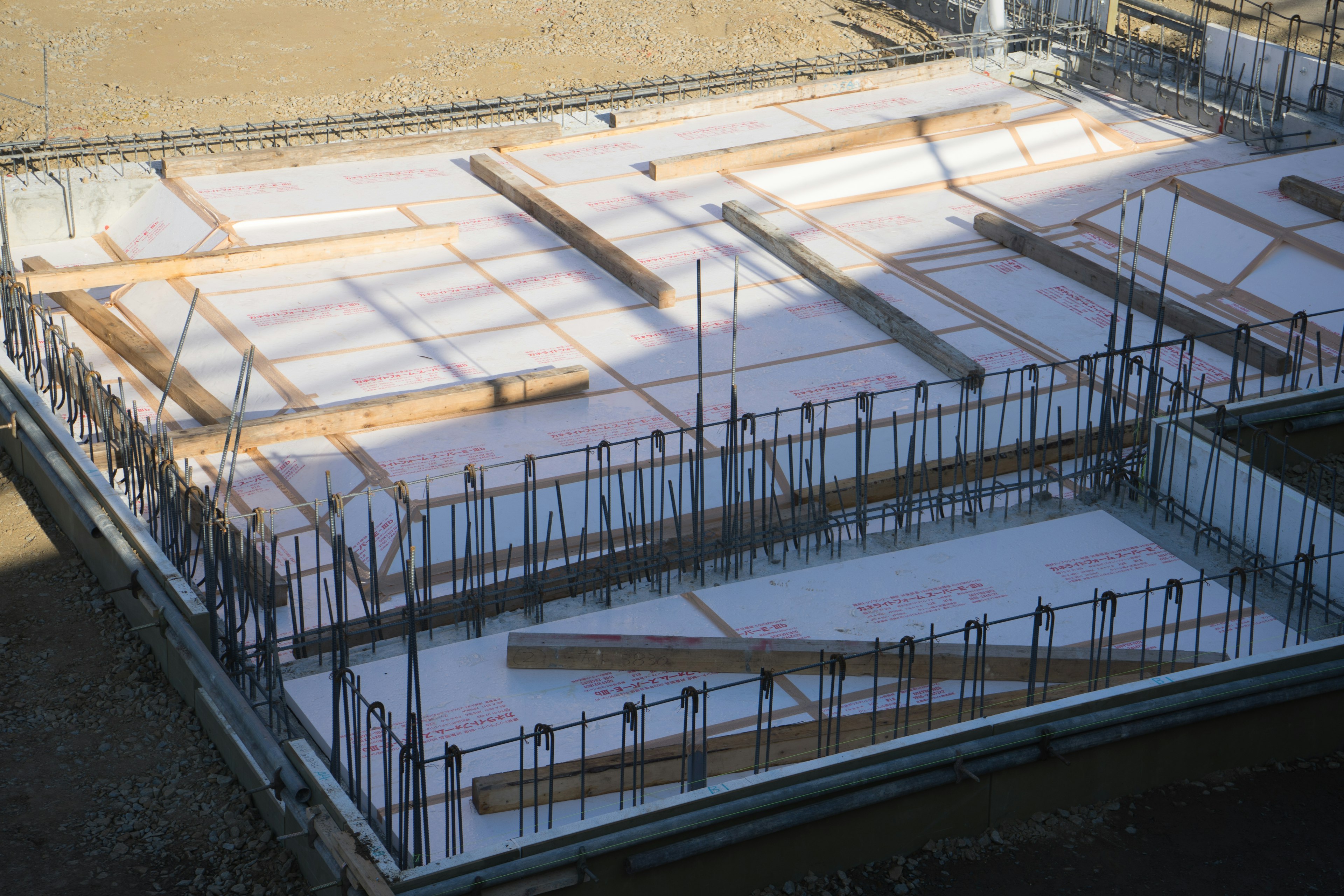 Concrete foundation at a construction site with wooden beams and rebar arranged