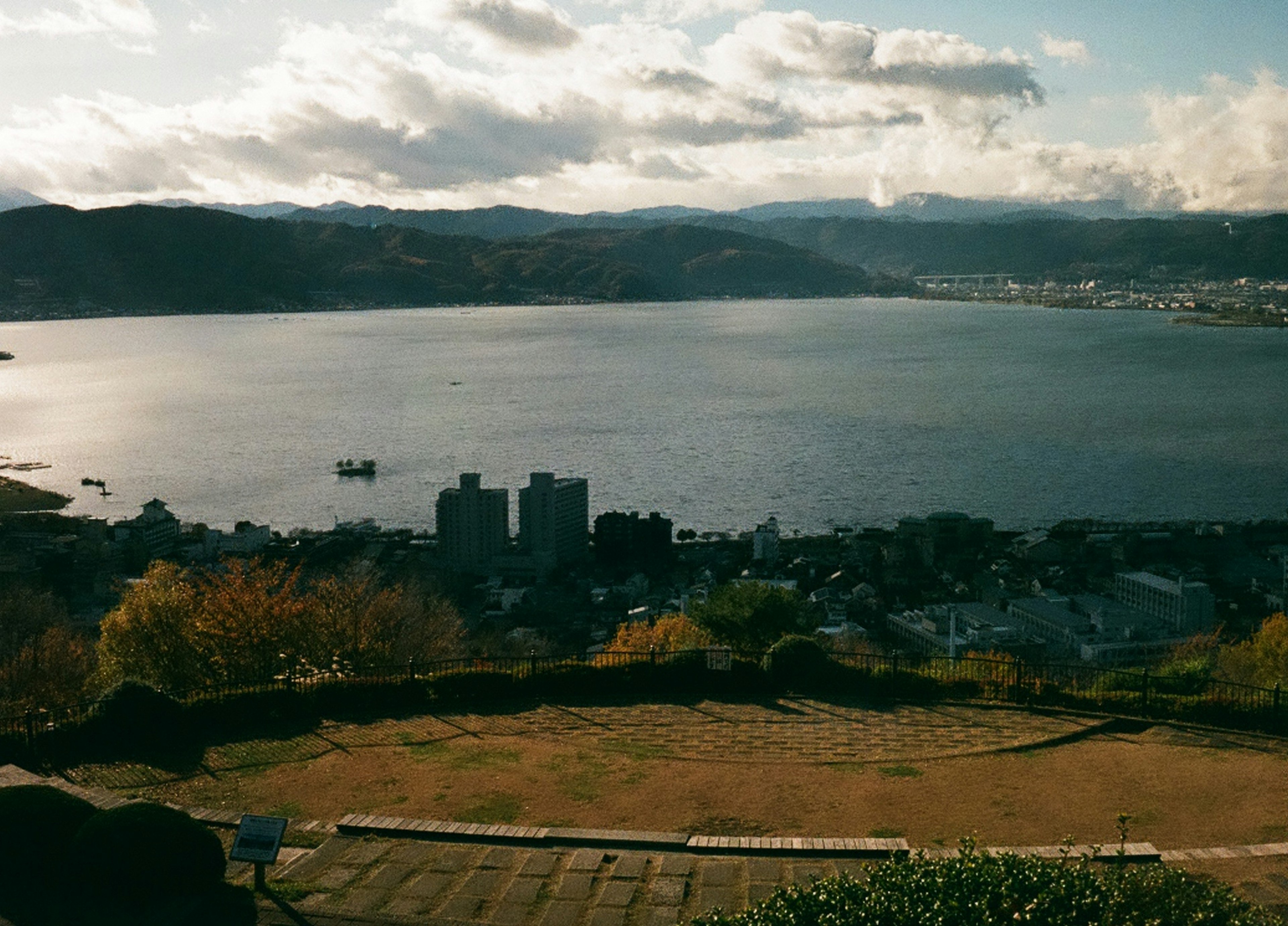 湖泊的风景，远处有山脉和前景中的小镇