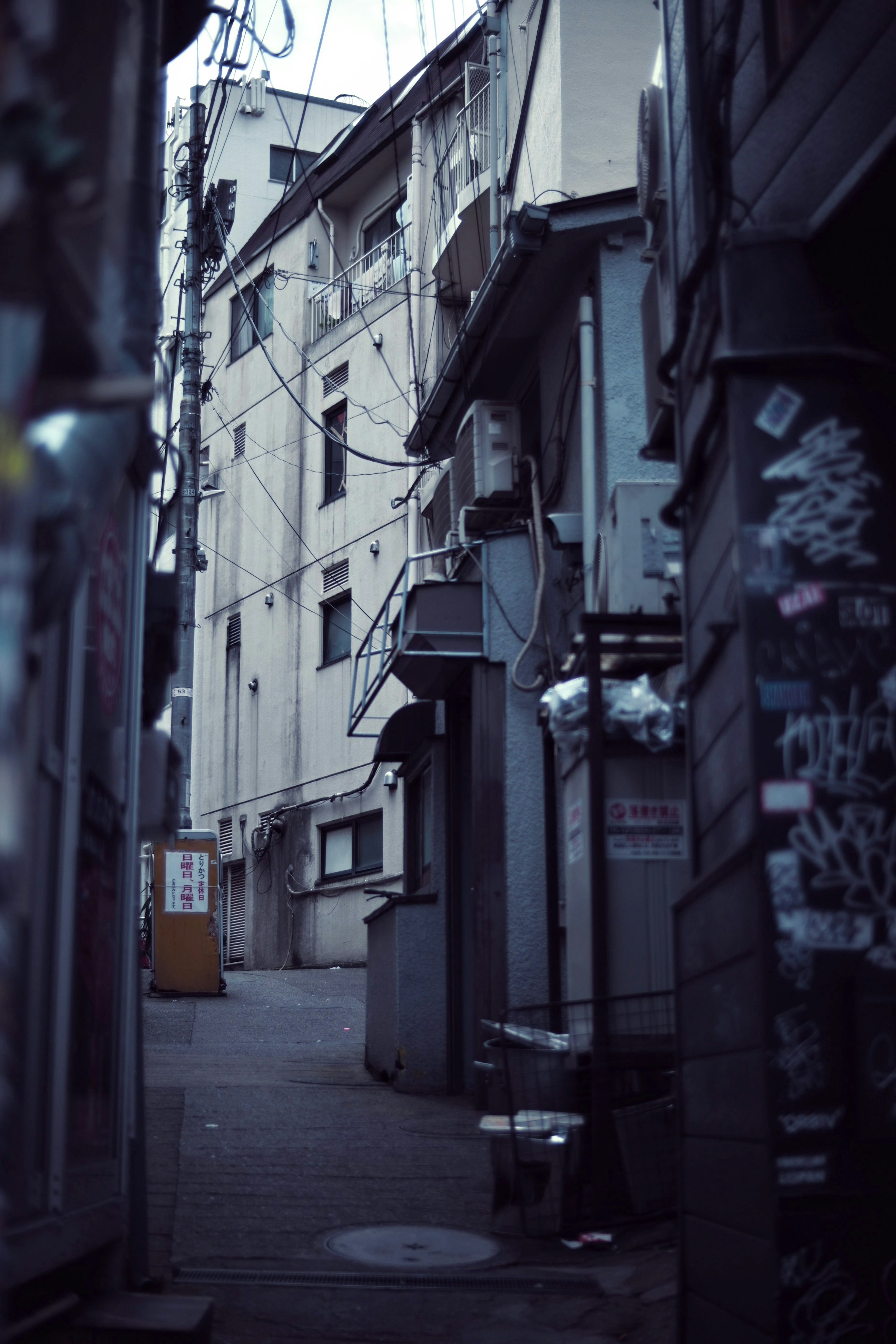 狭い路地に沿った古い建物と電線が見える風景