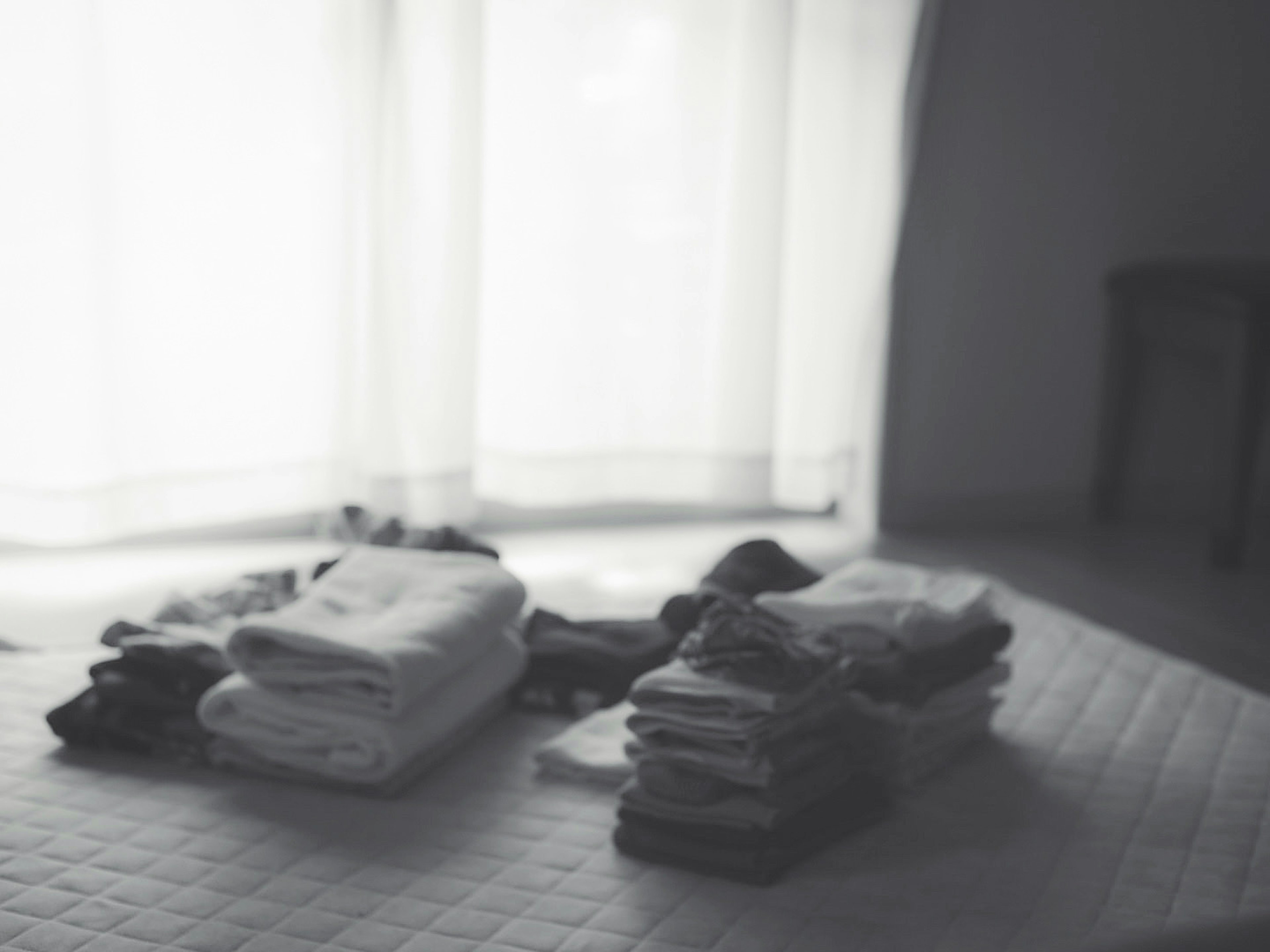 Neatly folded towels and clothes near a window