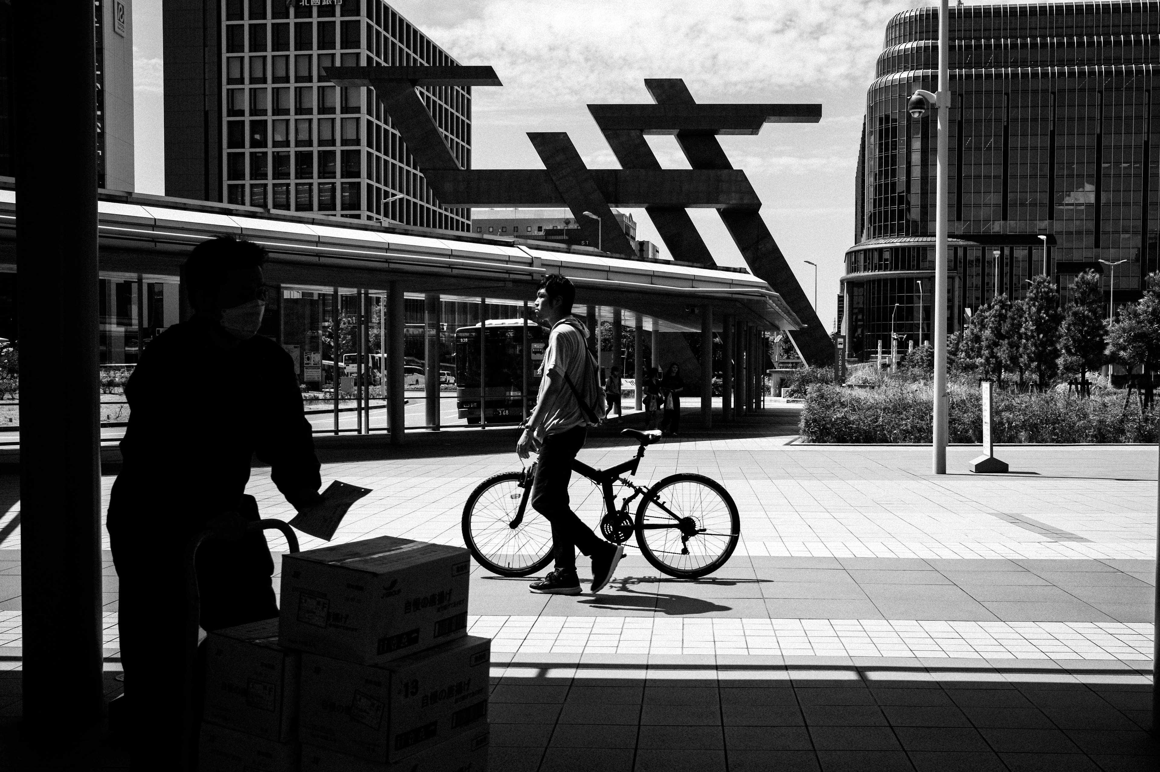 Escena urbana con una persona con una bicicleta y edificios modernos