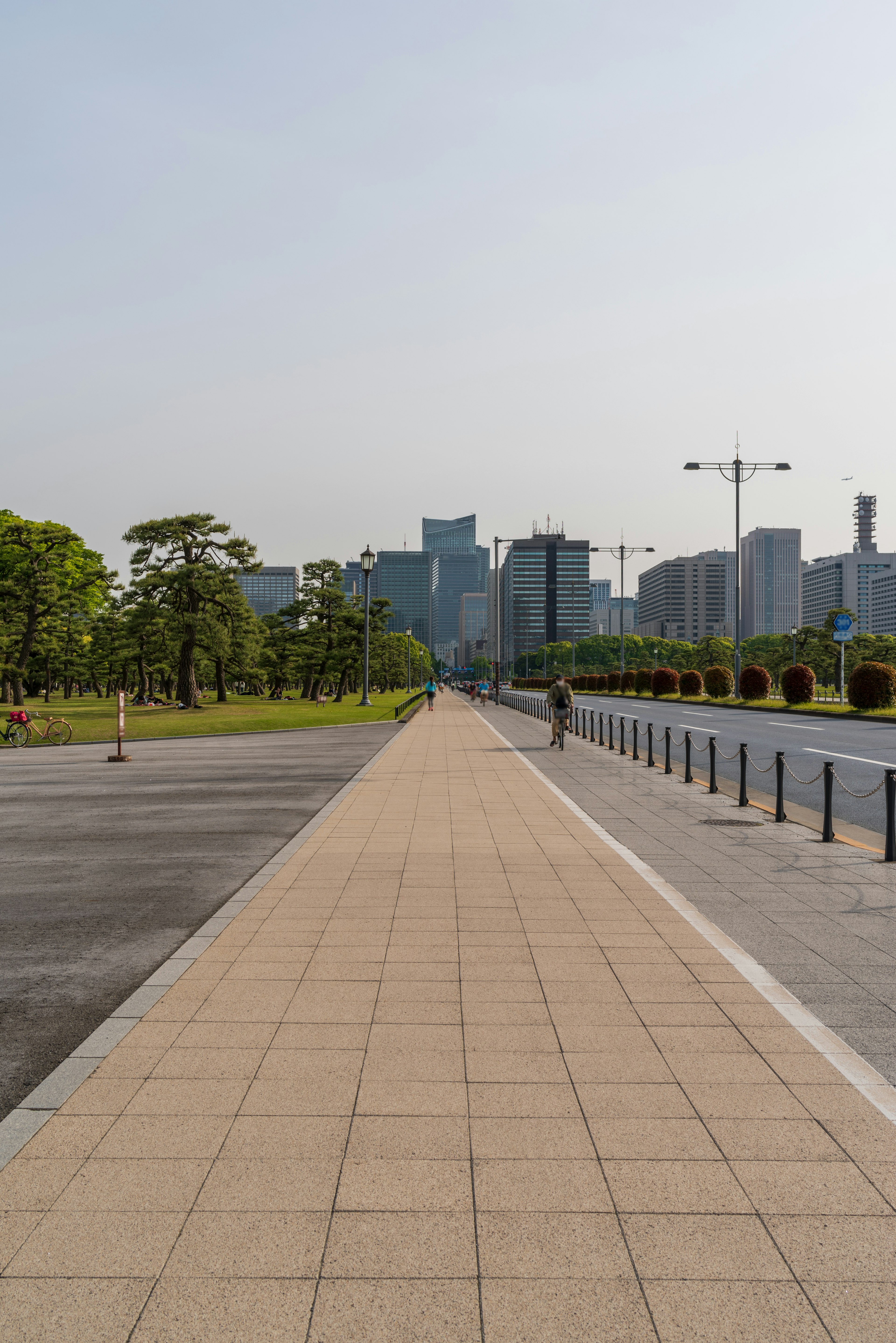 Breiter Gehweg mit einer Stadtansicht im Hintergrund