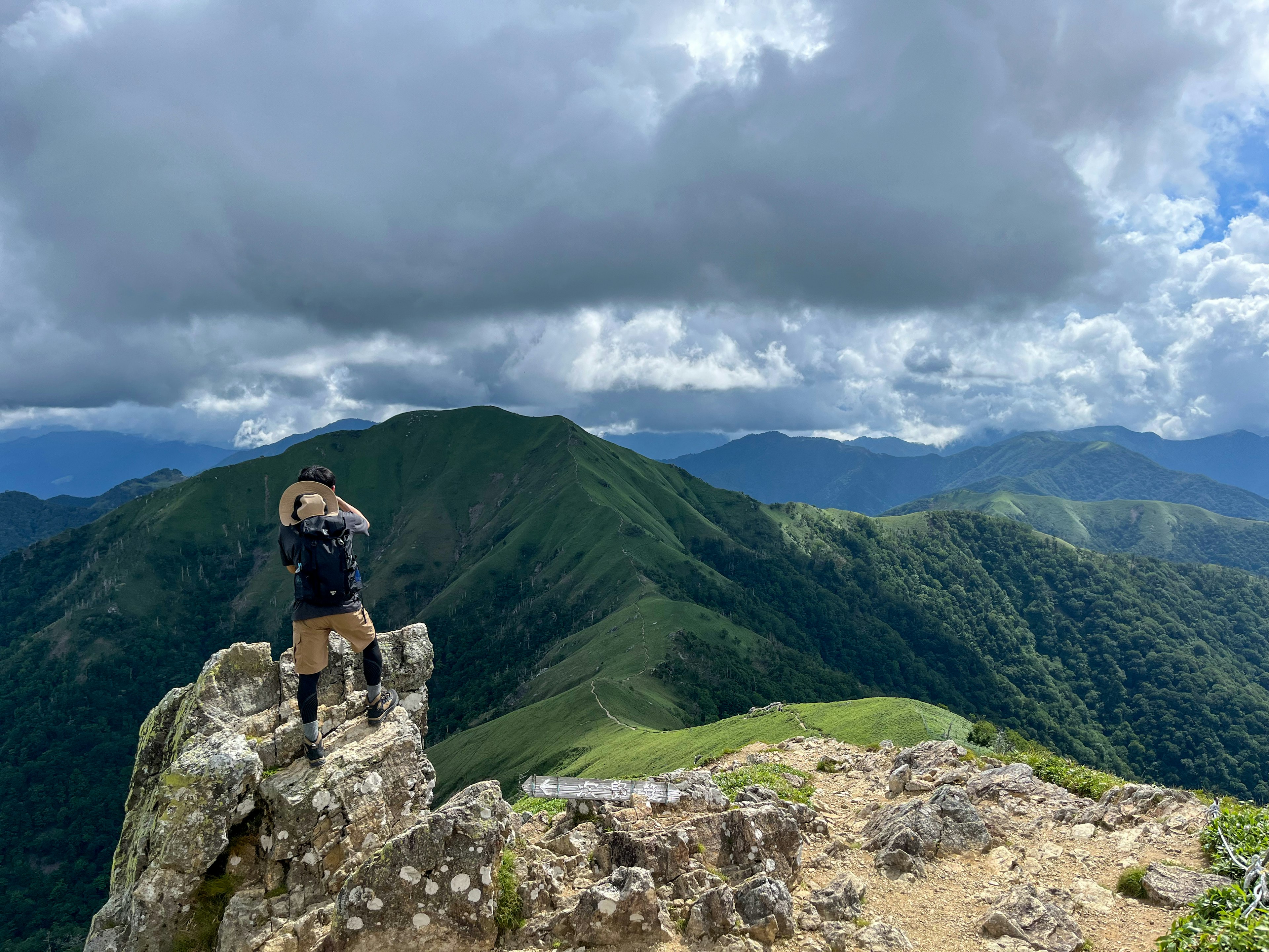 Wanderer steht auf einem Berggipfel mit einer schönen Landschaft