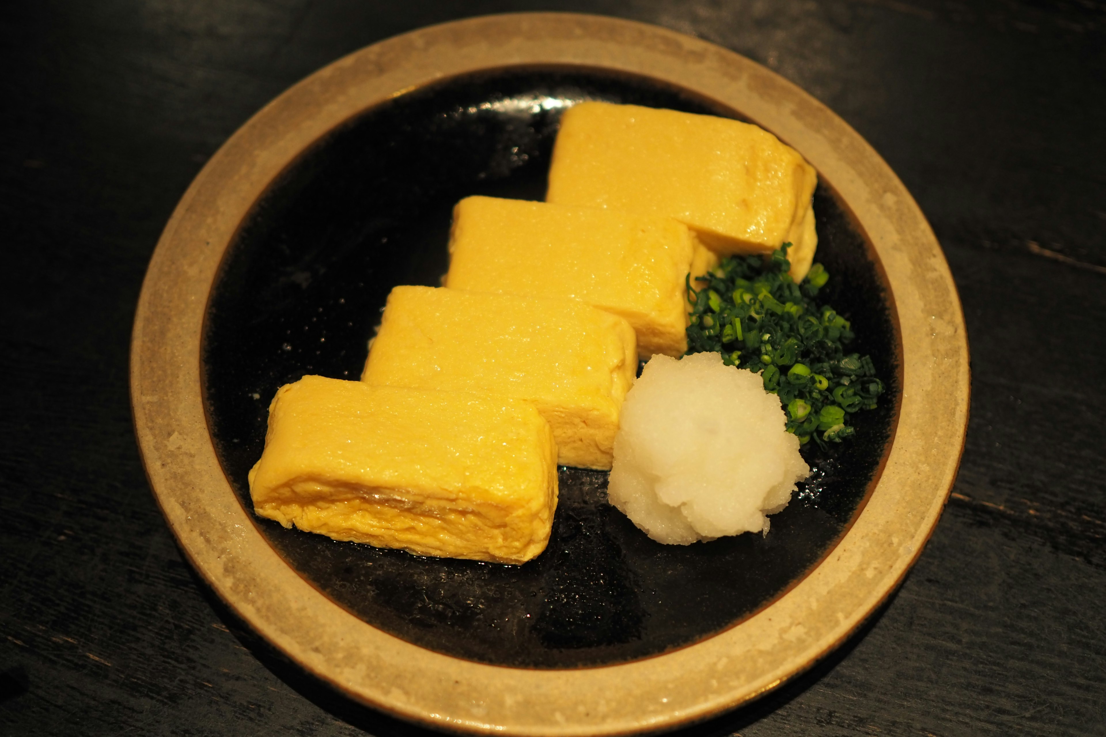 Beautifully plated Japanese omelette with grated daikon and green onions