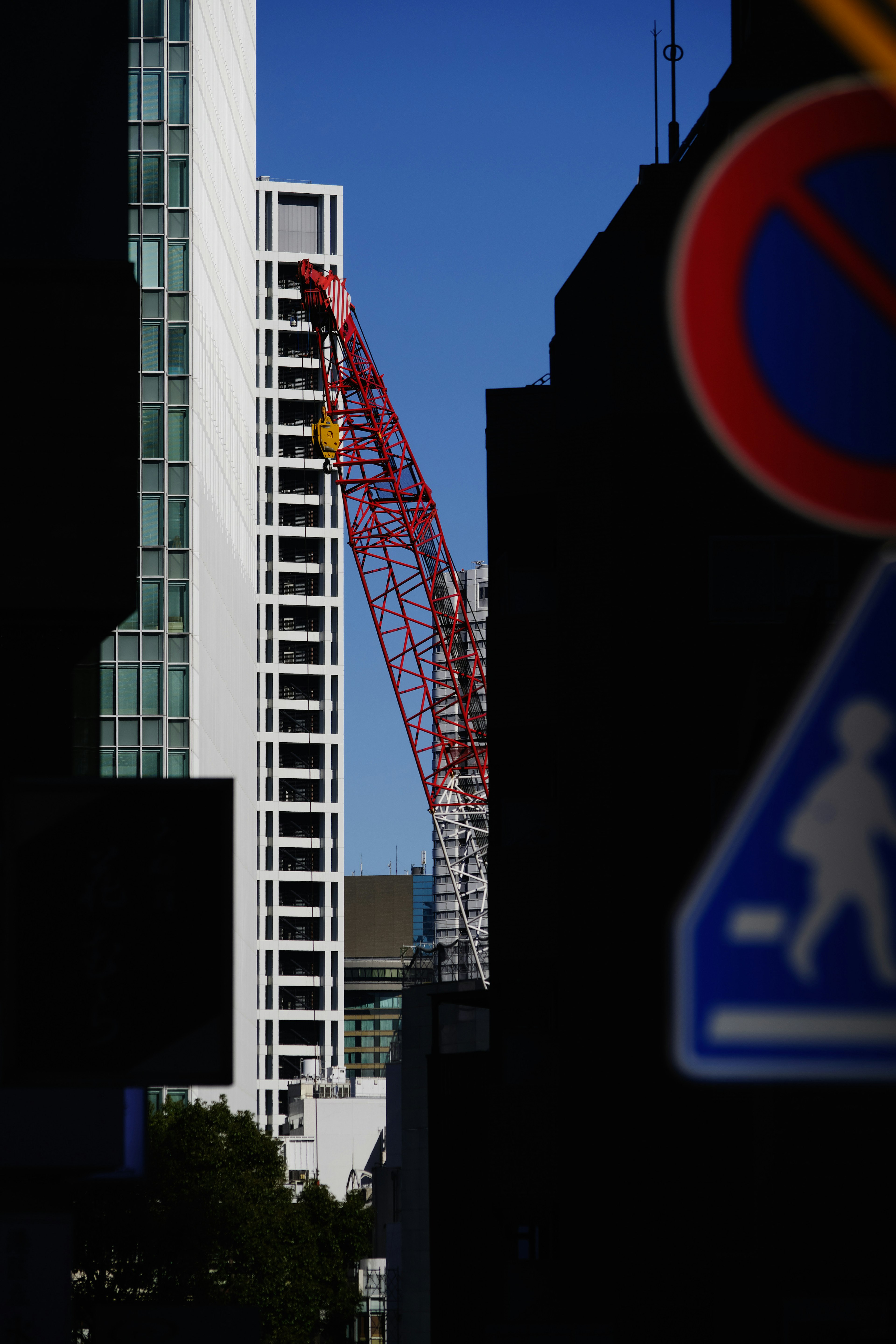 Urban landscape featuring a red crane between buildings