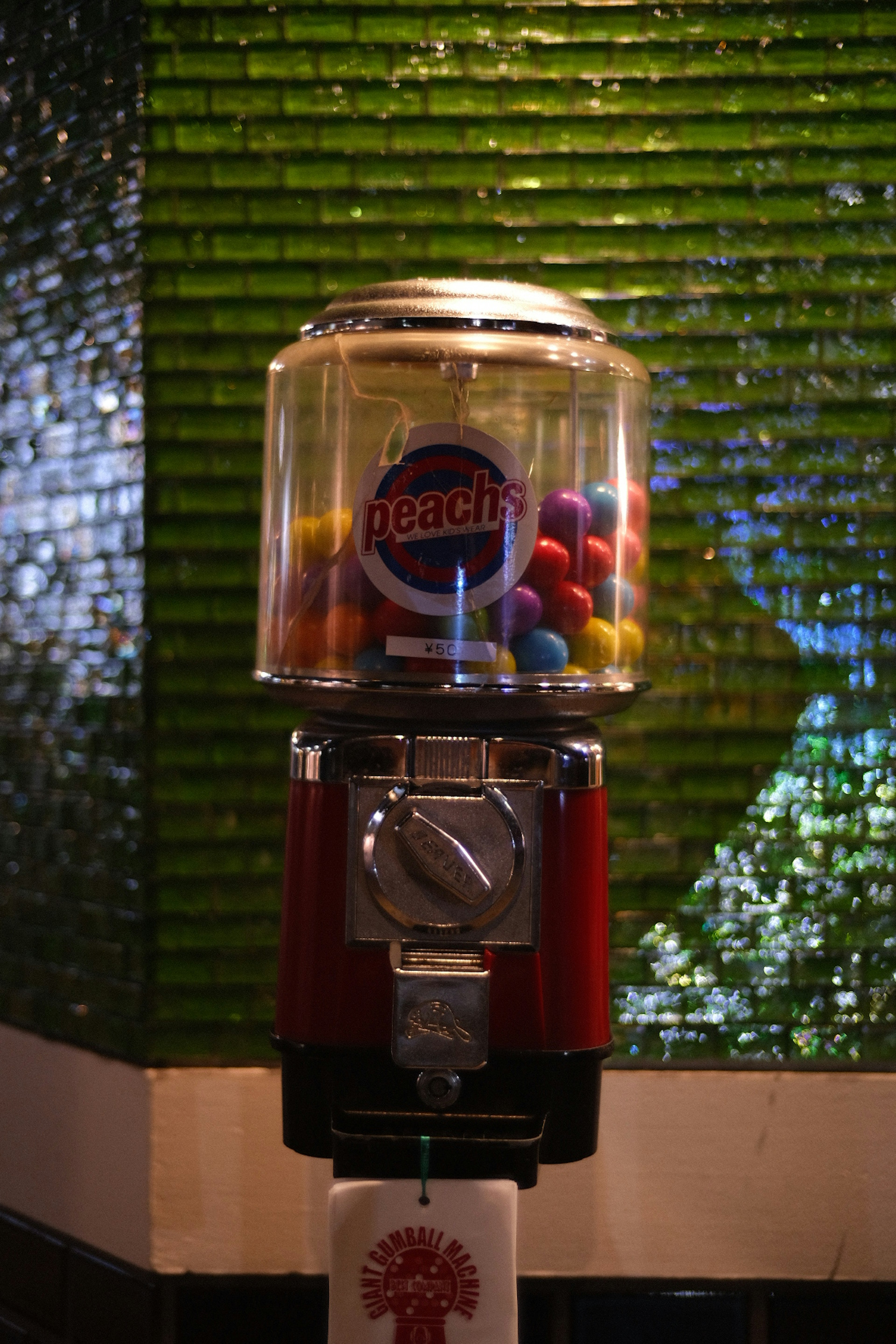 Colorful gumballs in a gumball machine with a red body