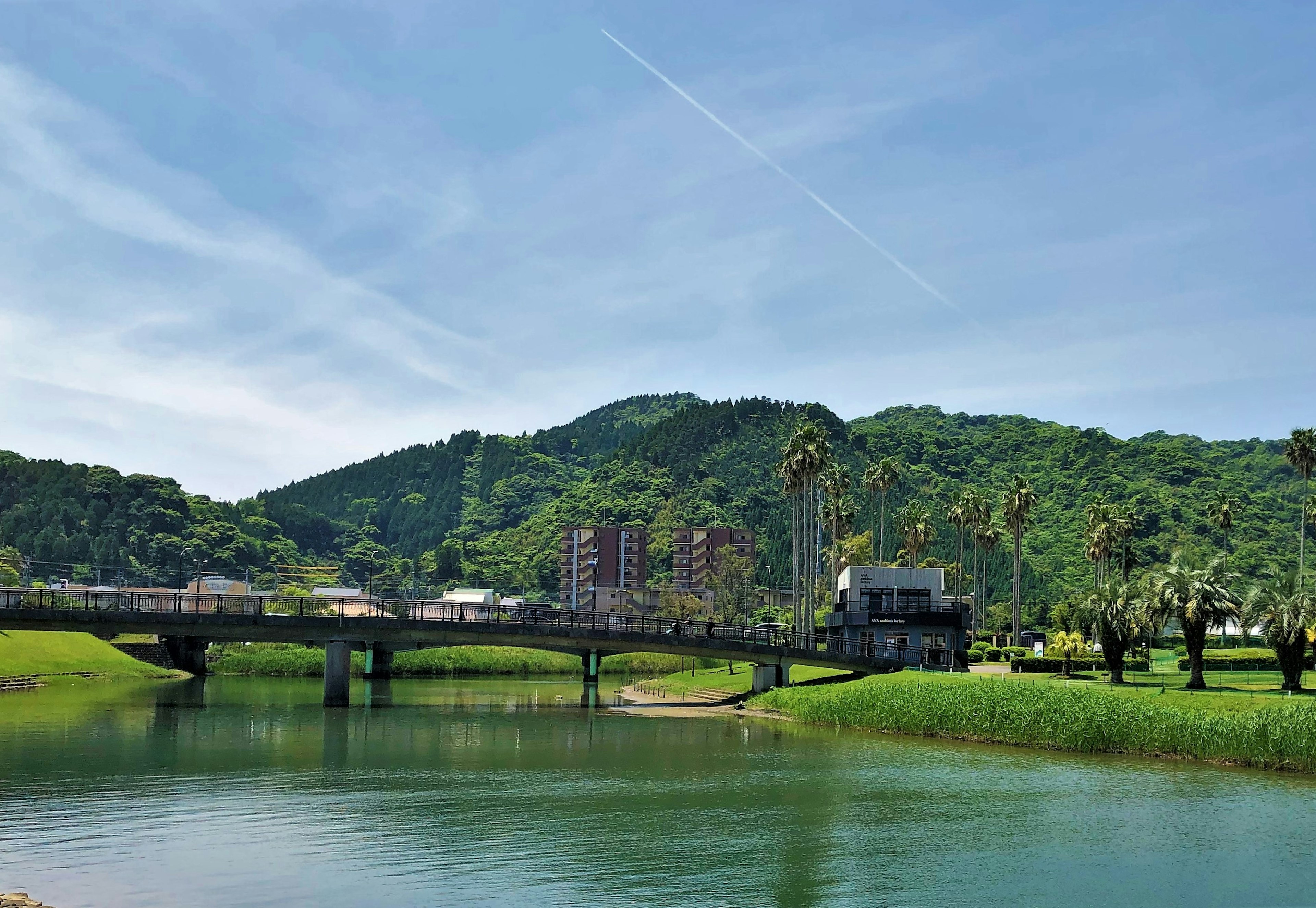 Vista escénica de un río y un puente con colinas verdes y cielo azul