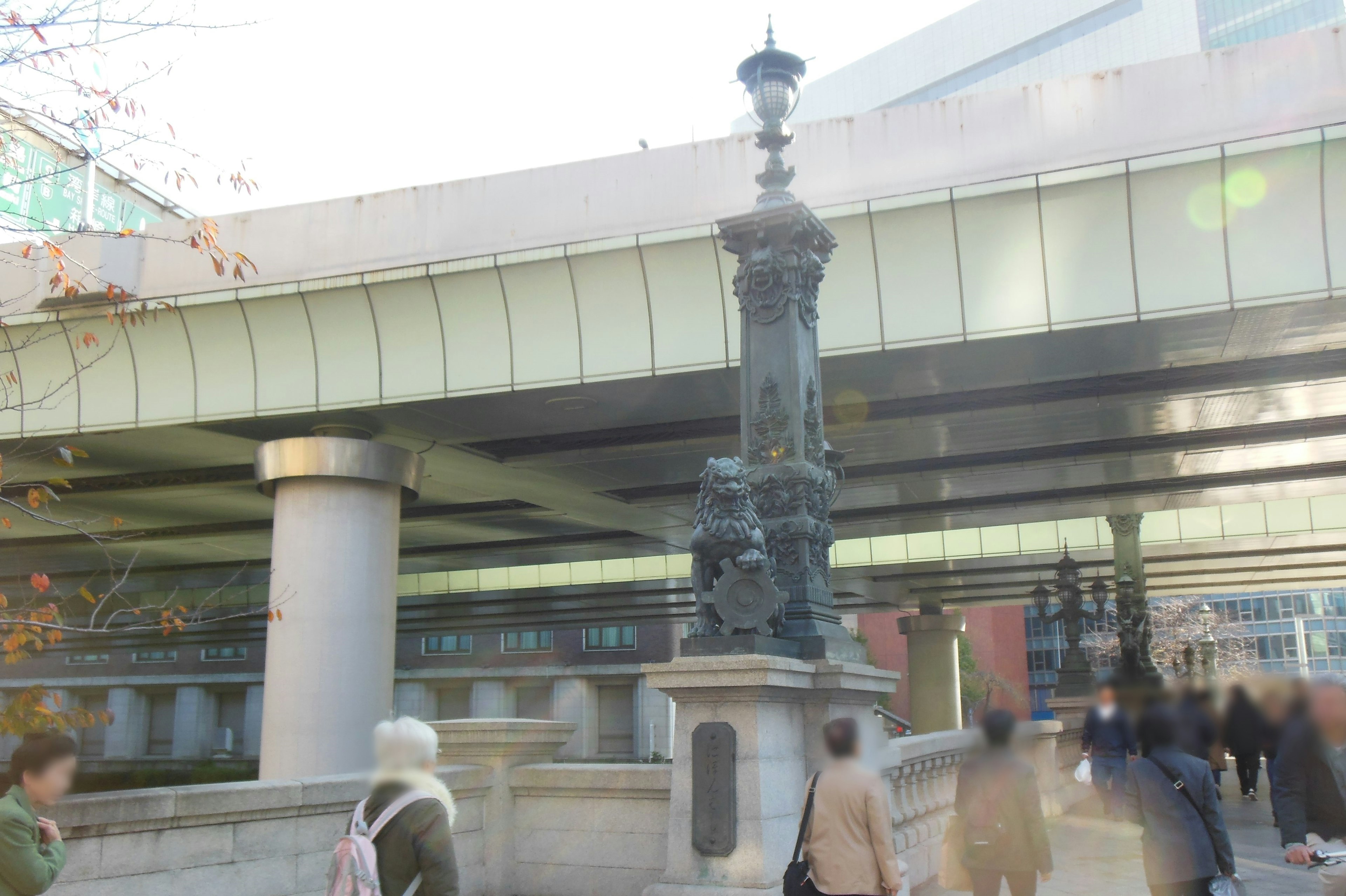 Decorative lantern under a bridge with pedestrians