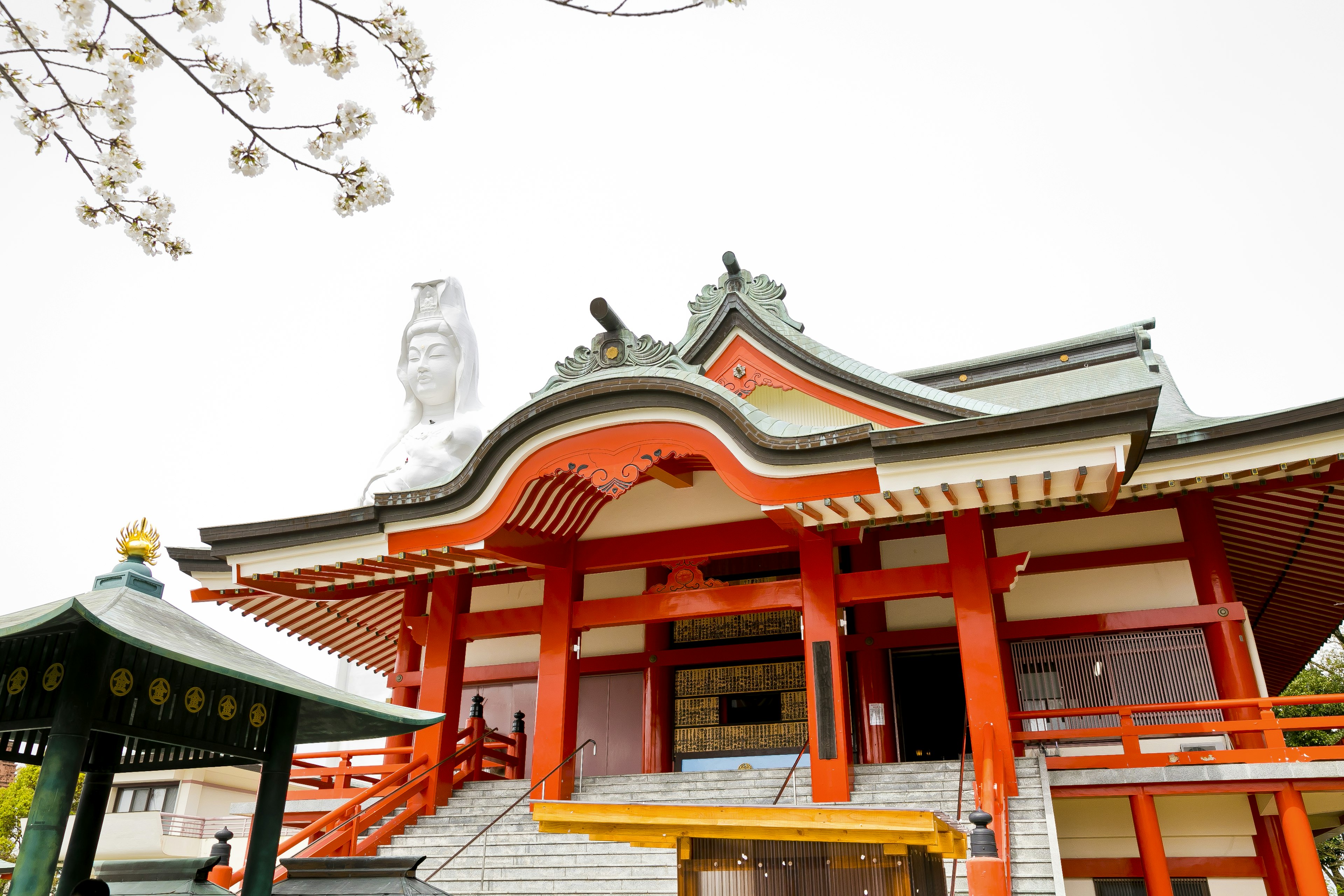 Traditional Japanese temple with red roof and cherry blossoms