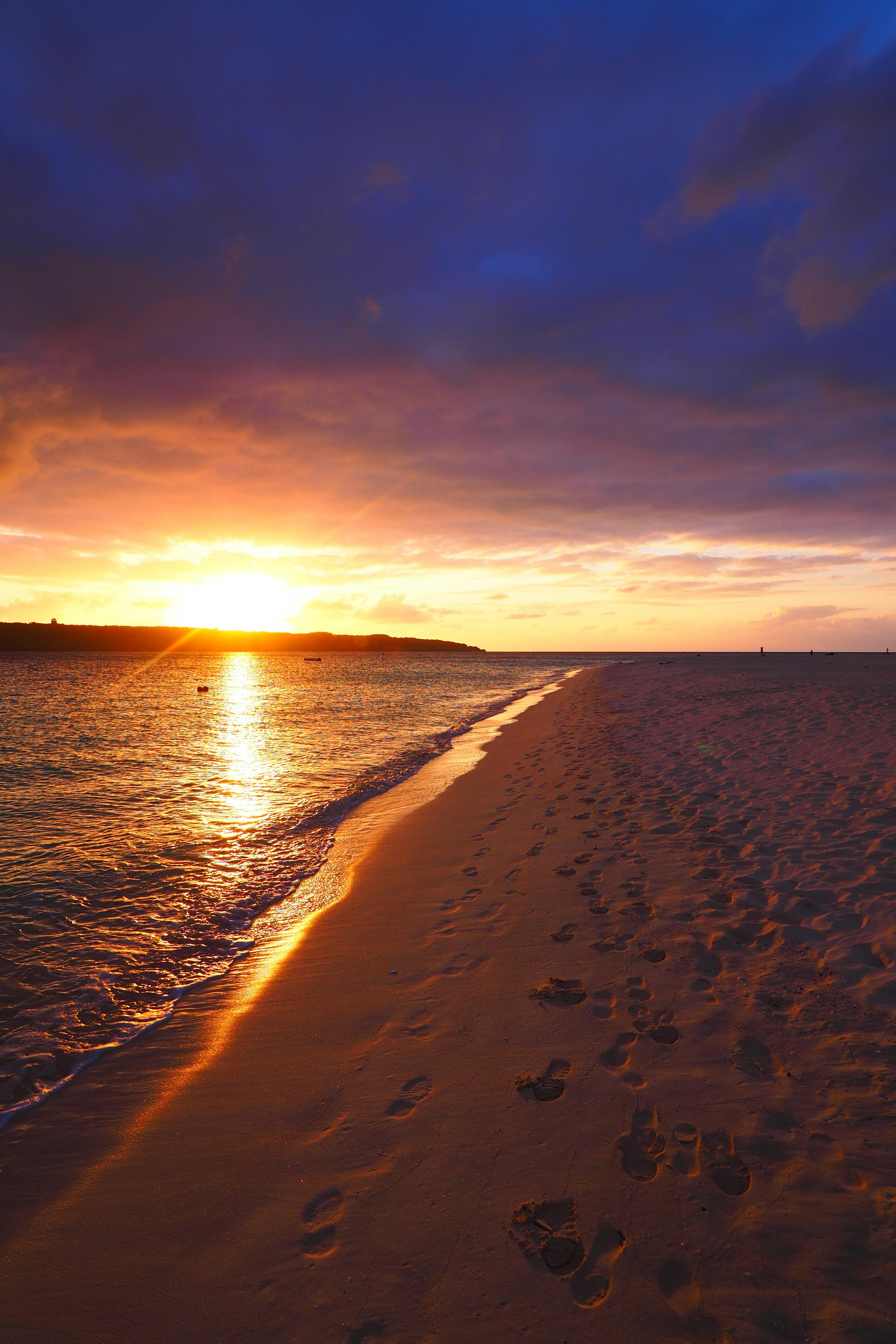 海灘風景夕陽下的沙灘腳印