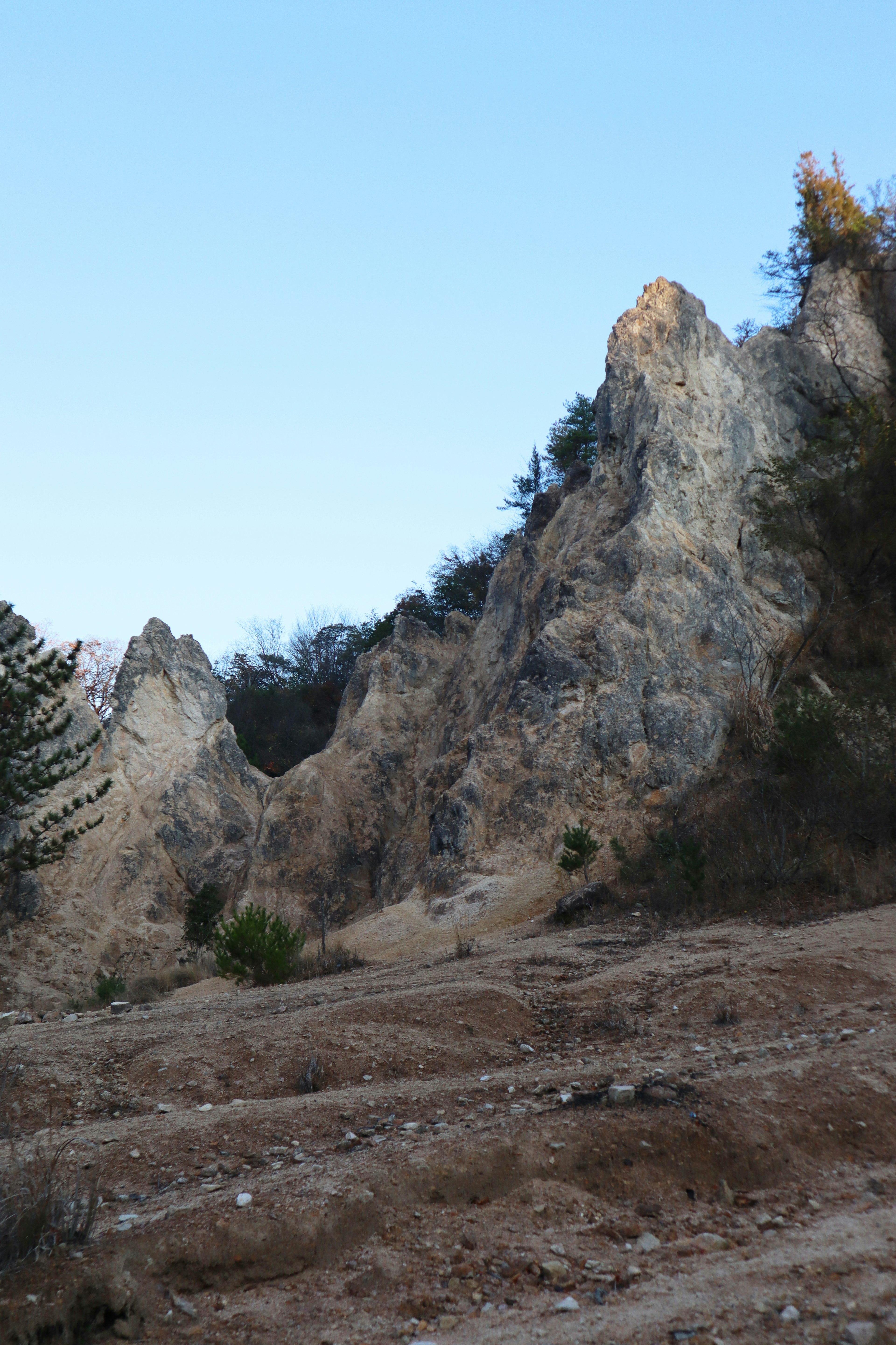 Paesaggio montano scosceso con formazioni rocciose e cielo blu