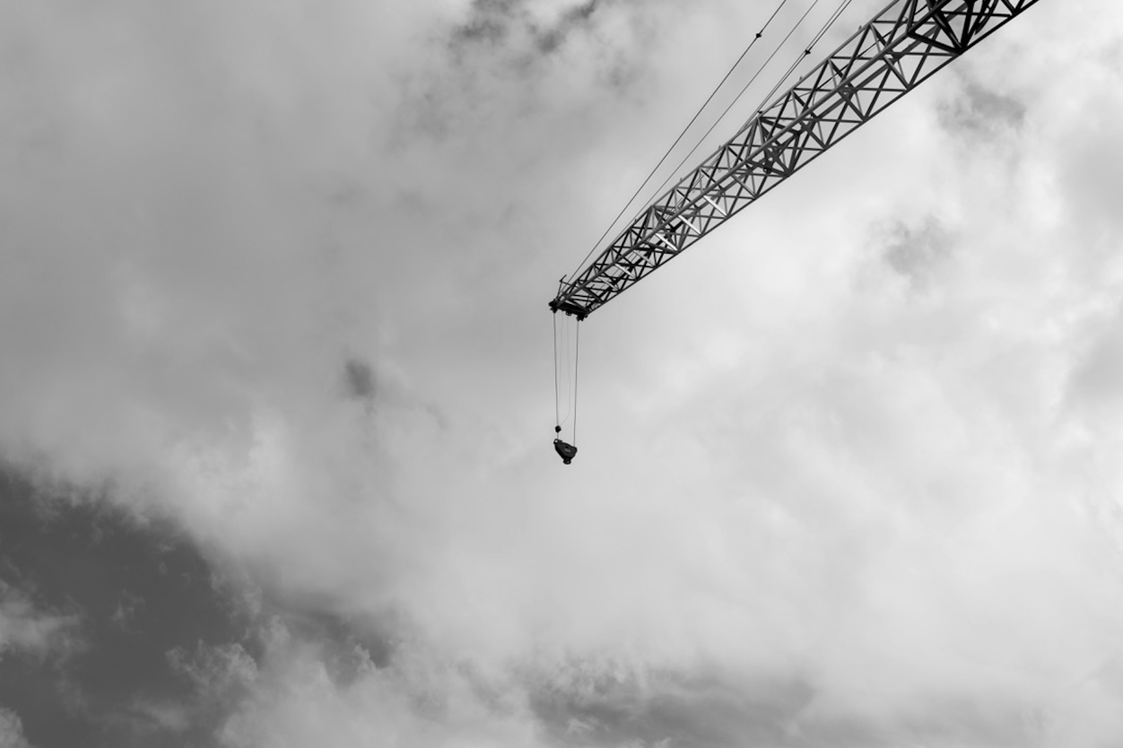 Black and white image of a crane extending into the sky