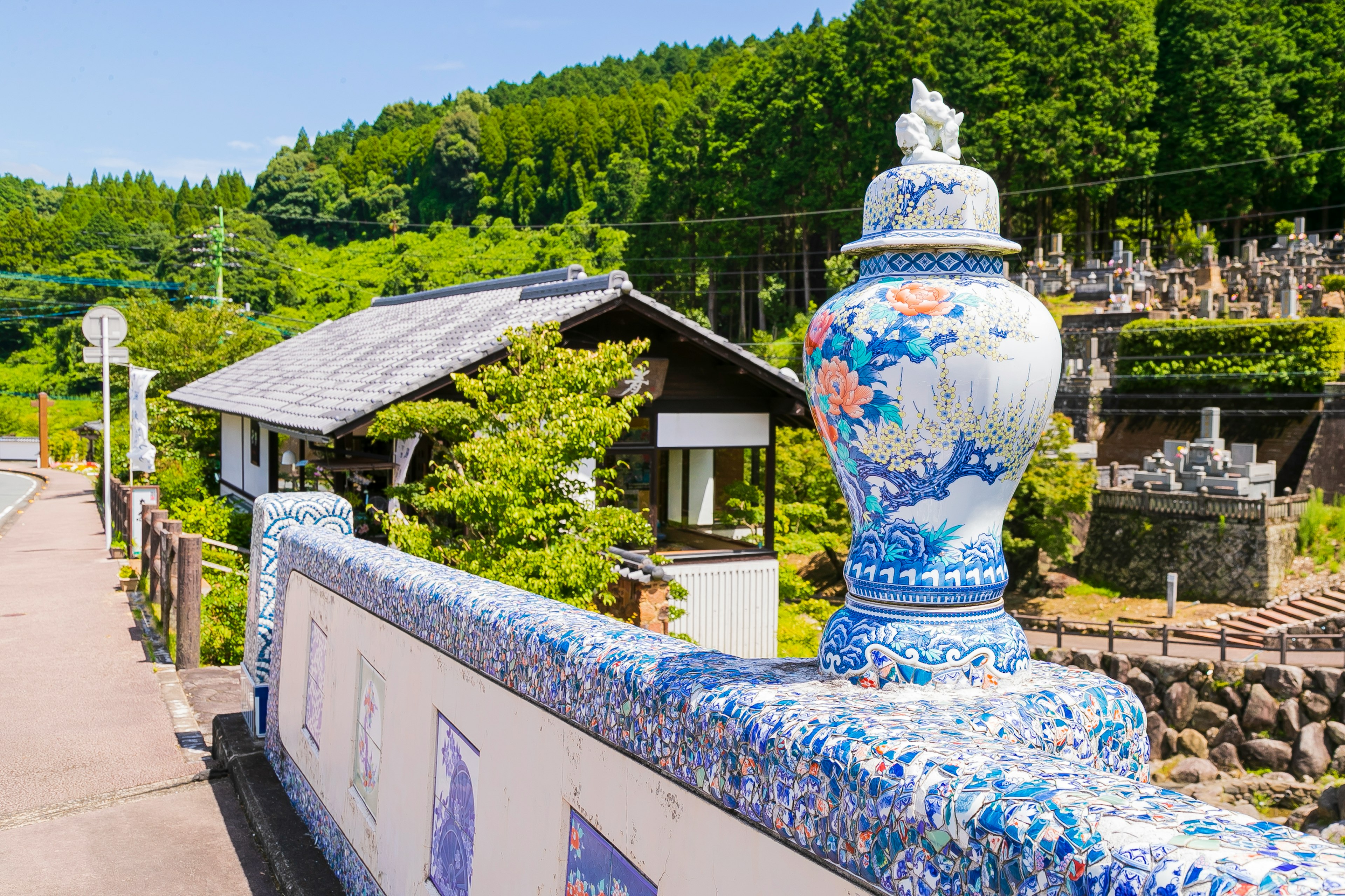 Große Vase mit blauen Blumenmustern in einer malerischen Landschaft