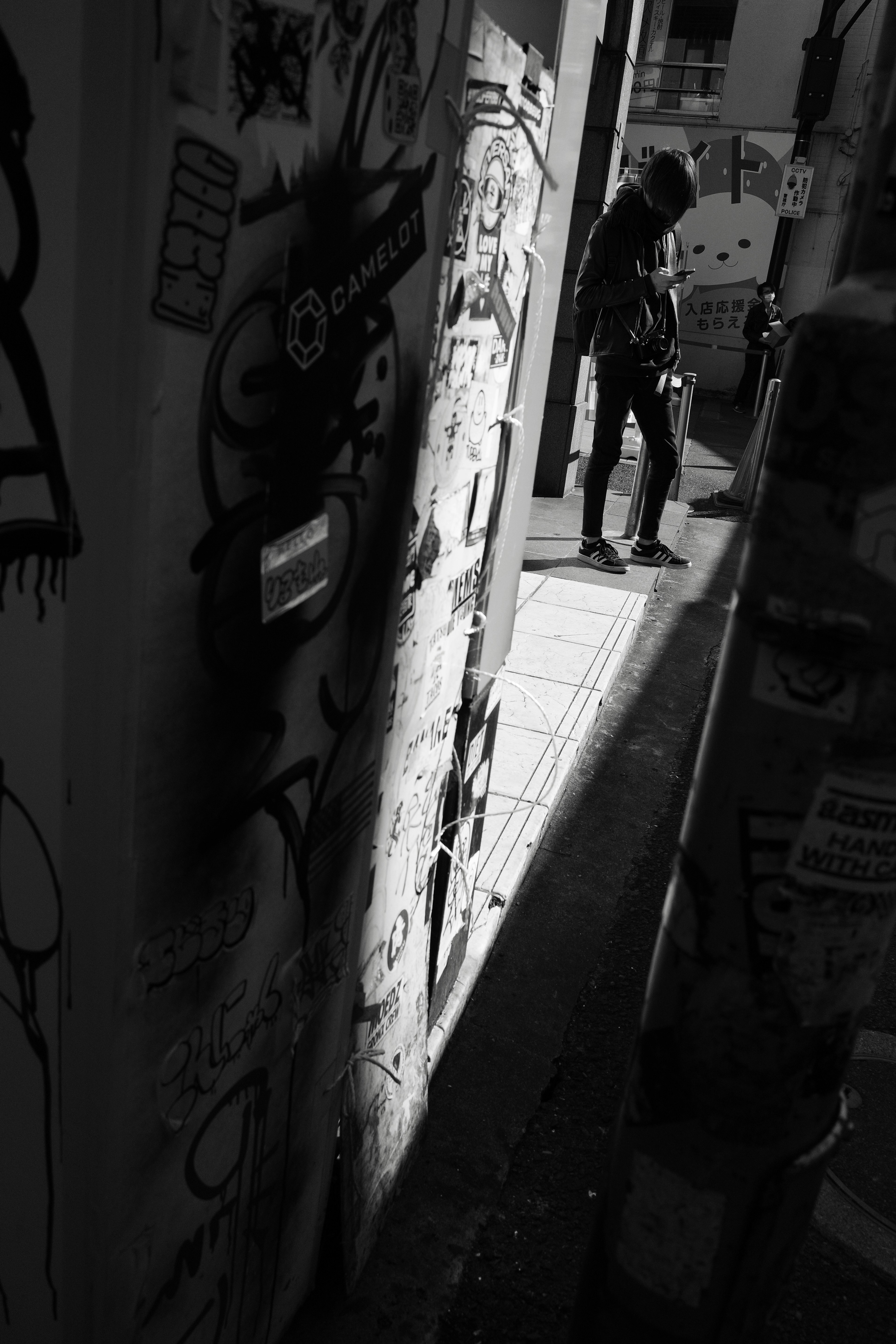 Person standing in a dark alley with graffiti on the walls