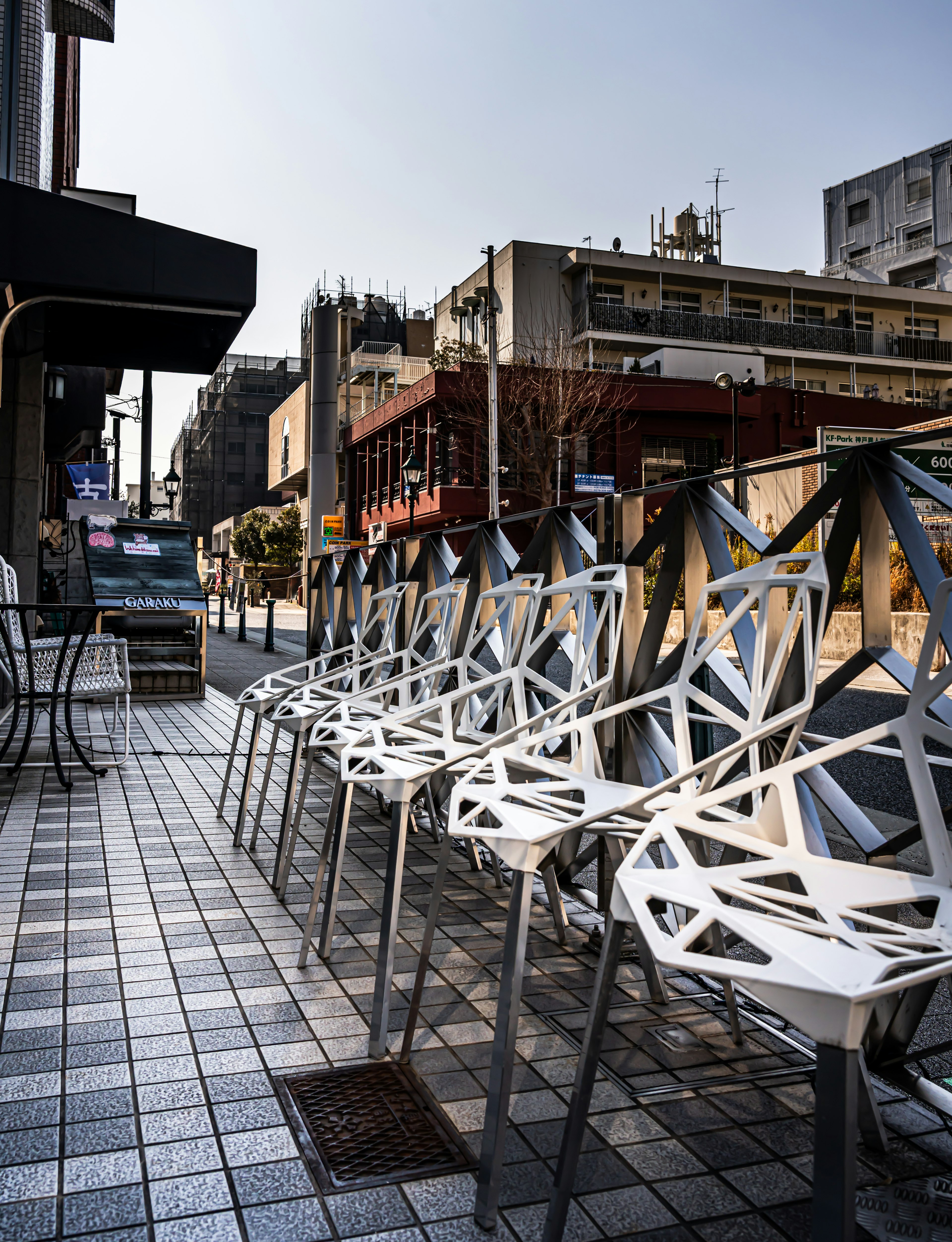 Sillas blancas geométricas alineadas en una calle de la ciudad