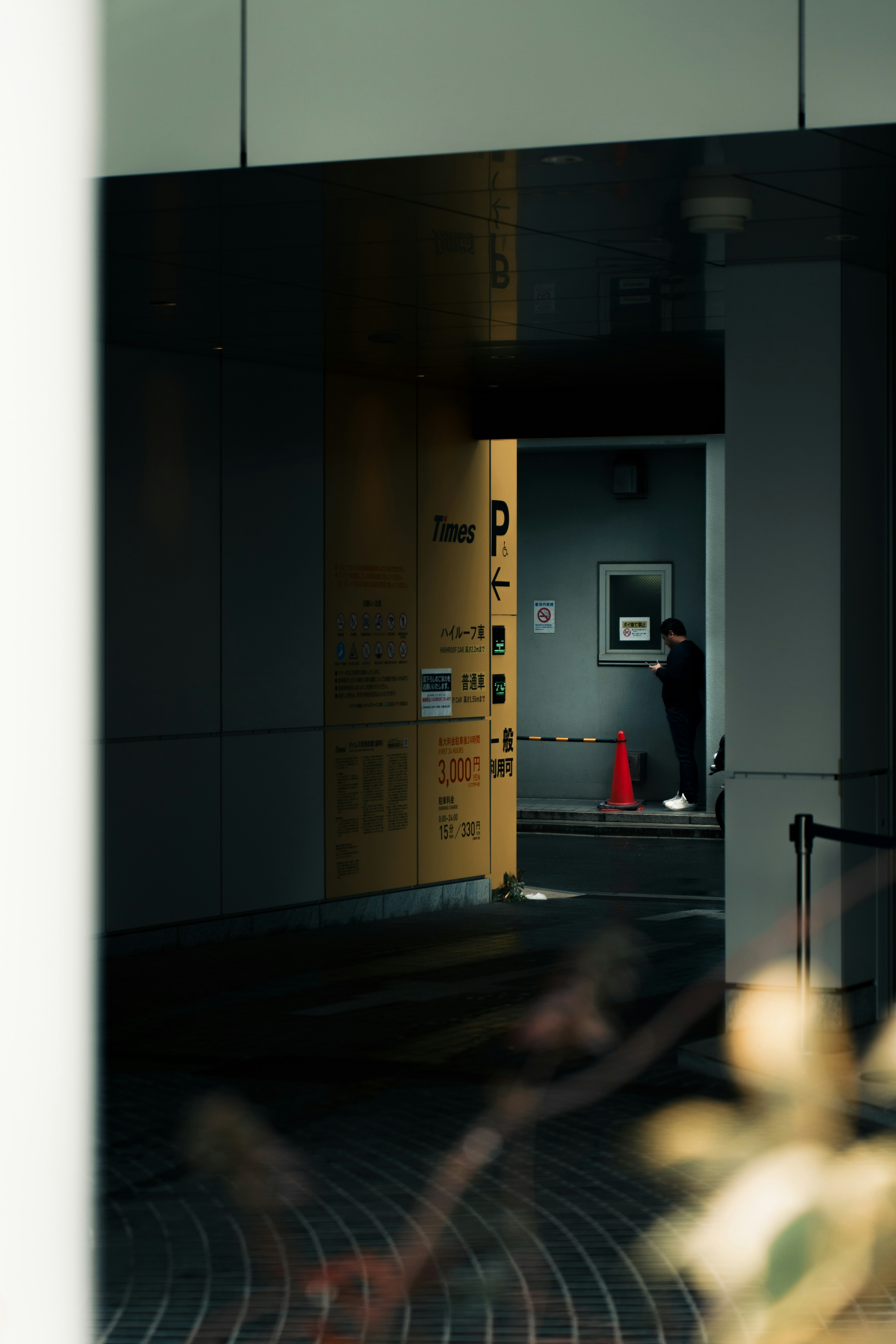 A doorway at the end of a dim corridor with a red cone visible