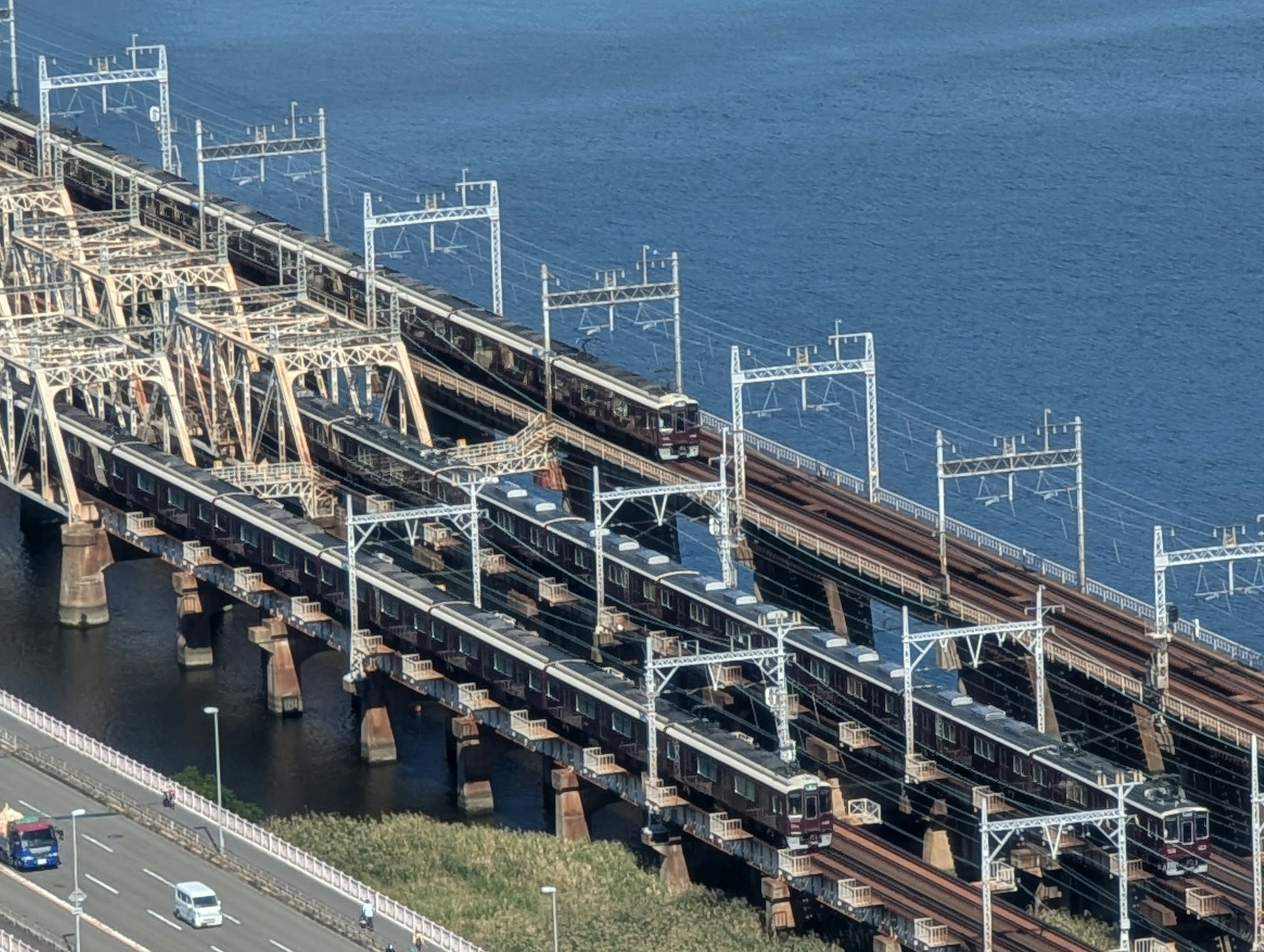 Vista aérea de un puente de tren con trenes cruzando el agua