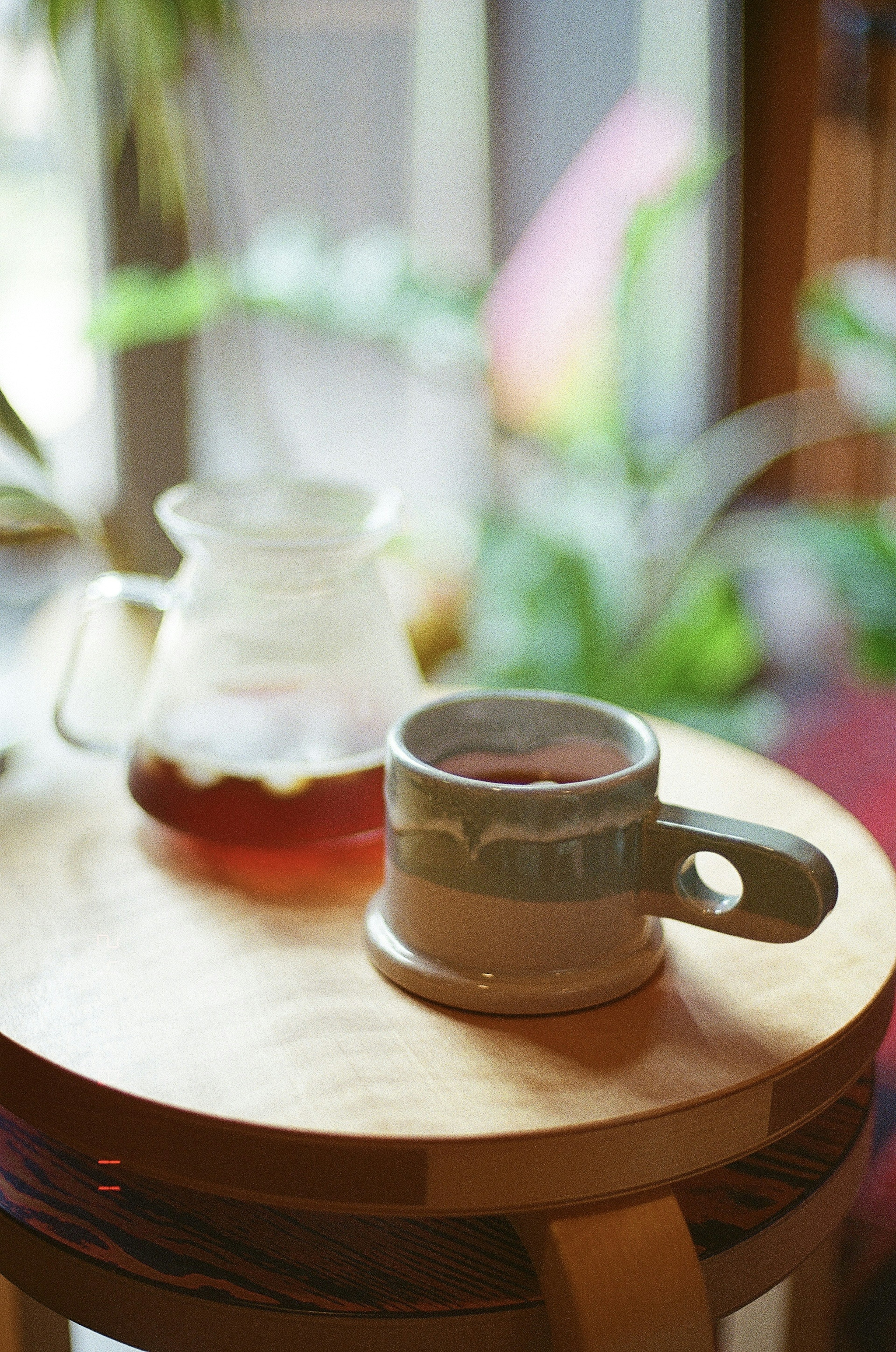 Coffee cup and brewing pot on a wooden table