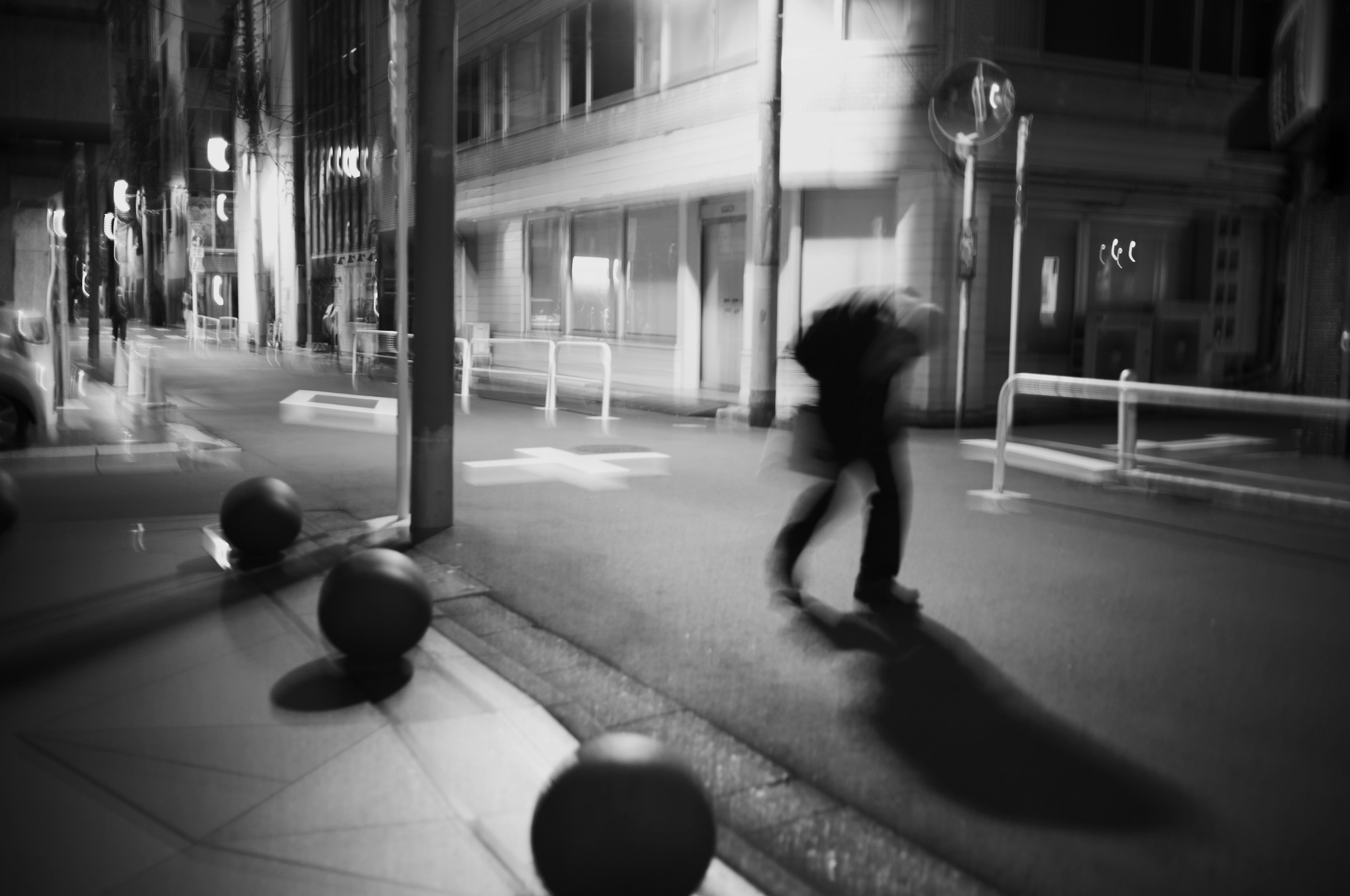 Silhouette d'une personne marchant dans un environnement urbain nocturne avec une esthétique monochrome