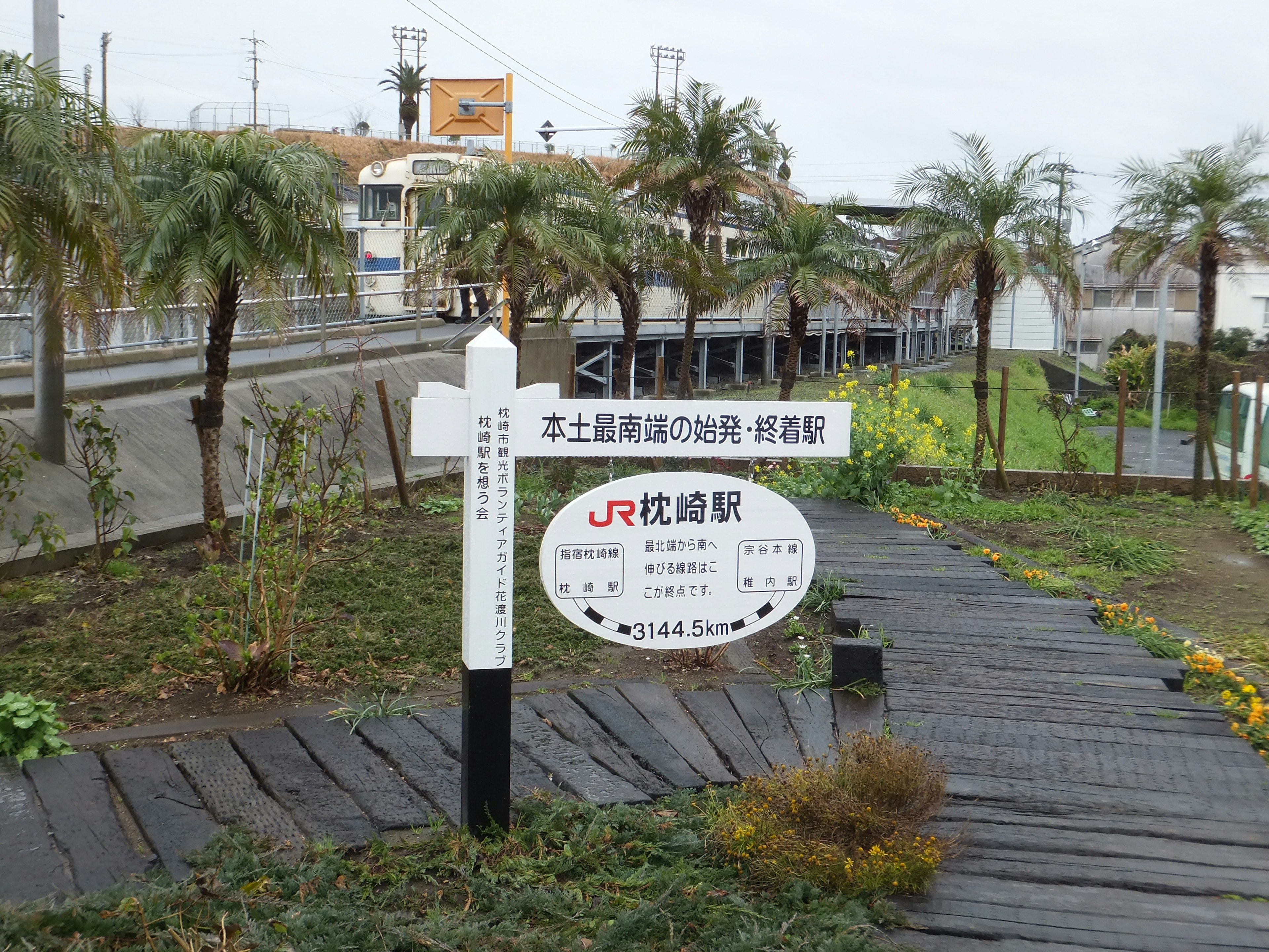 Signpost for JR Station surrounded by greenery