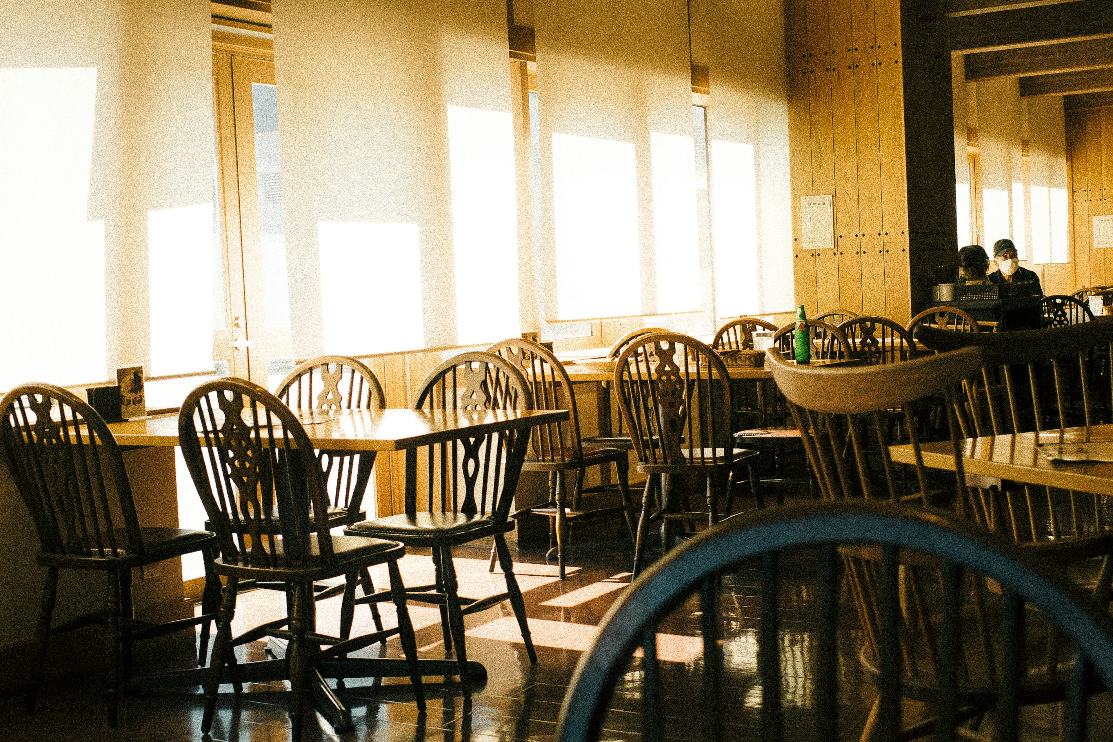 Interno di un caffè con ampie finestre luminose e tavoli in legno