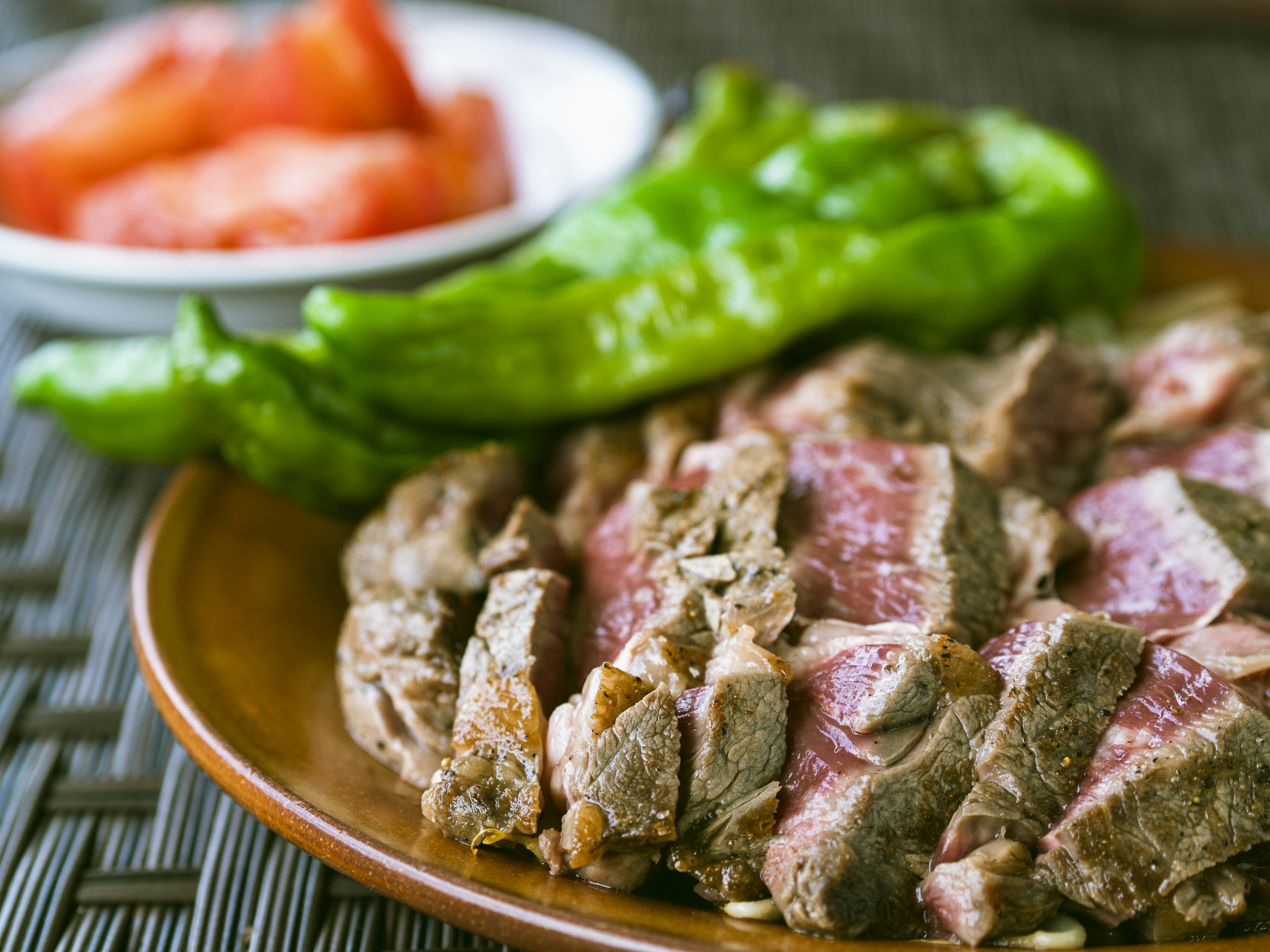 Boeuf tranché servi avec des tomates fraîches et des poivrons verts