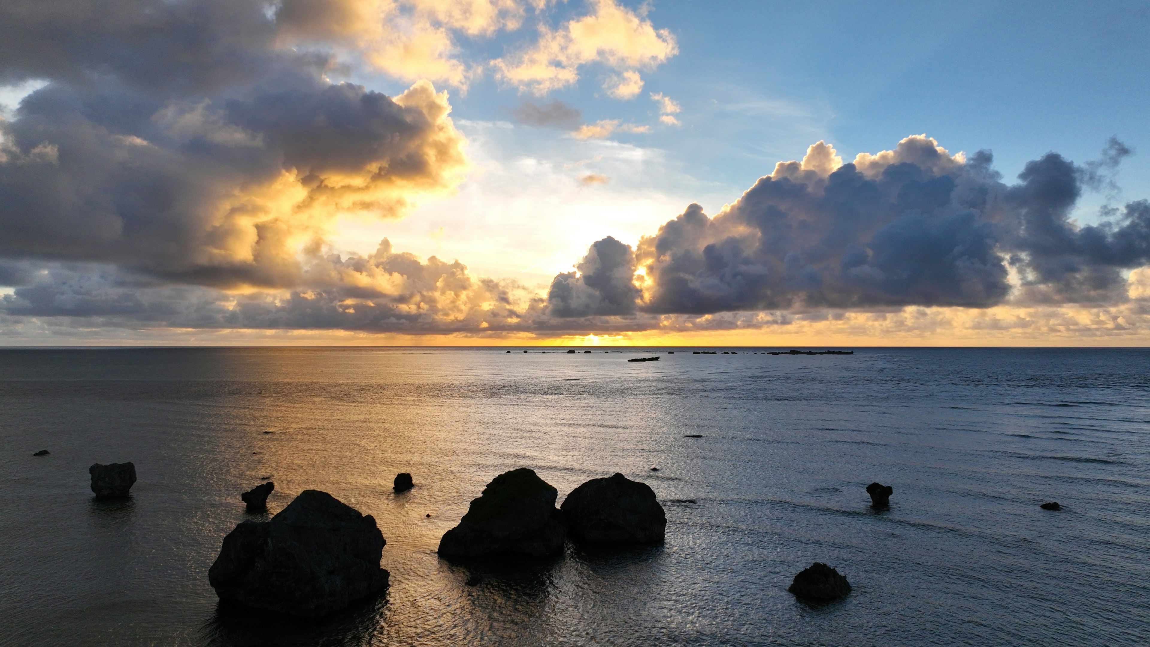 美しい海の景色に沈む夕日と岩