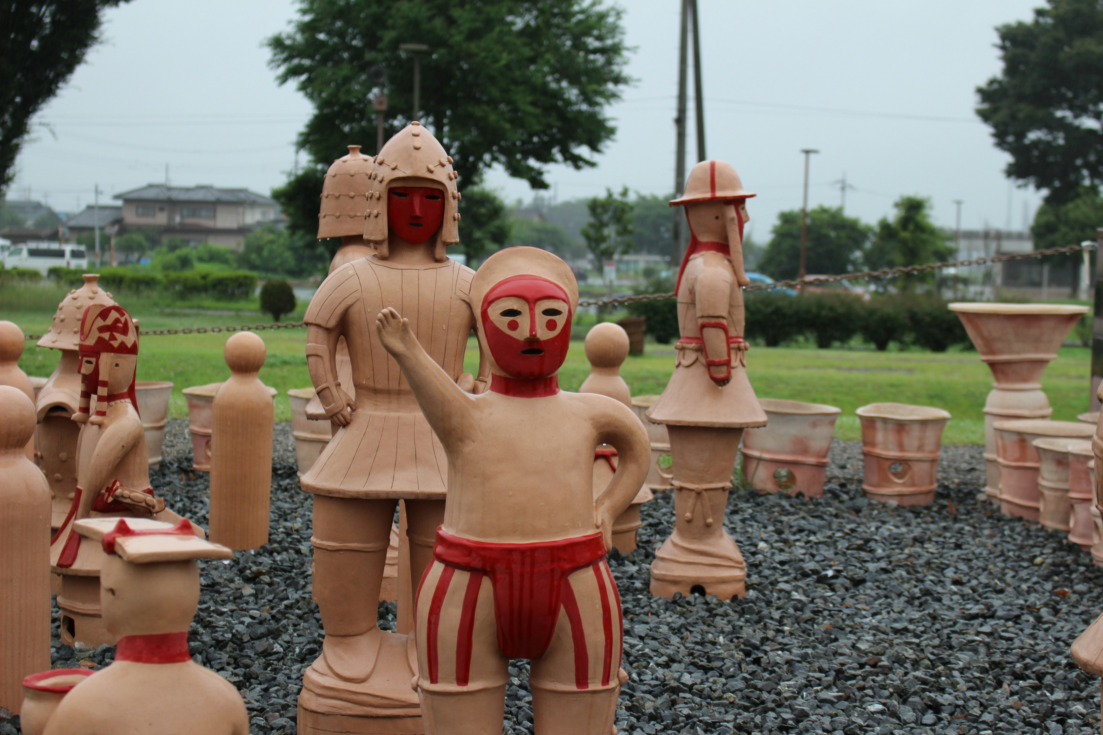 Une scène de parc avec des figures en terre cuite aux couleurs vives et un arrière-plan vert