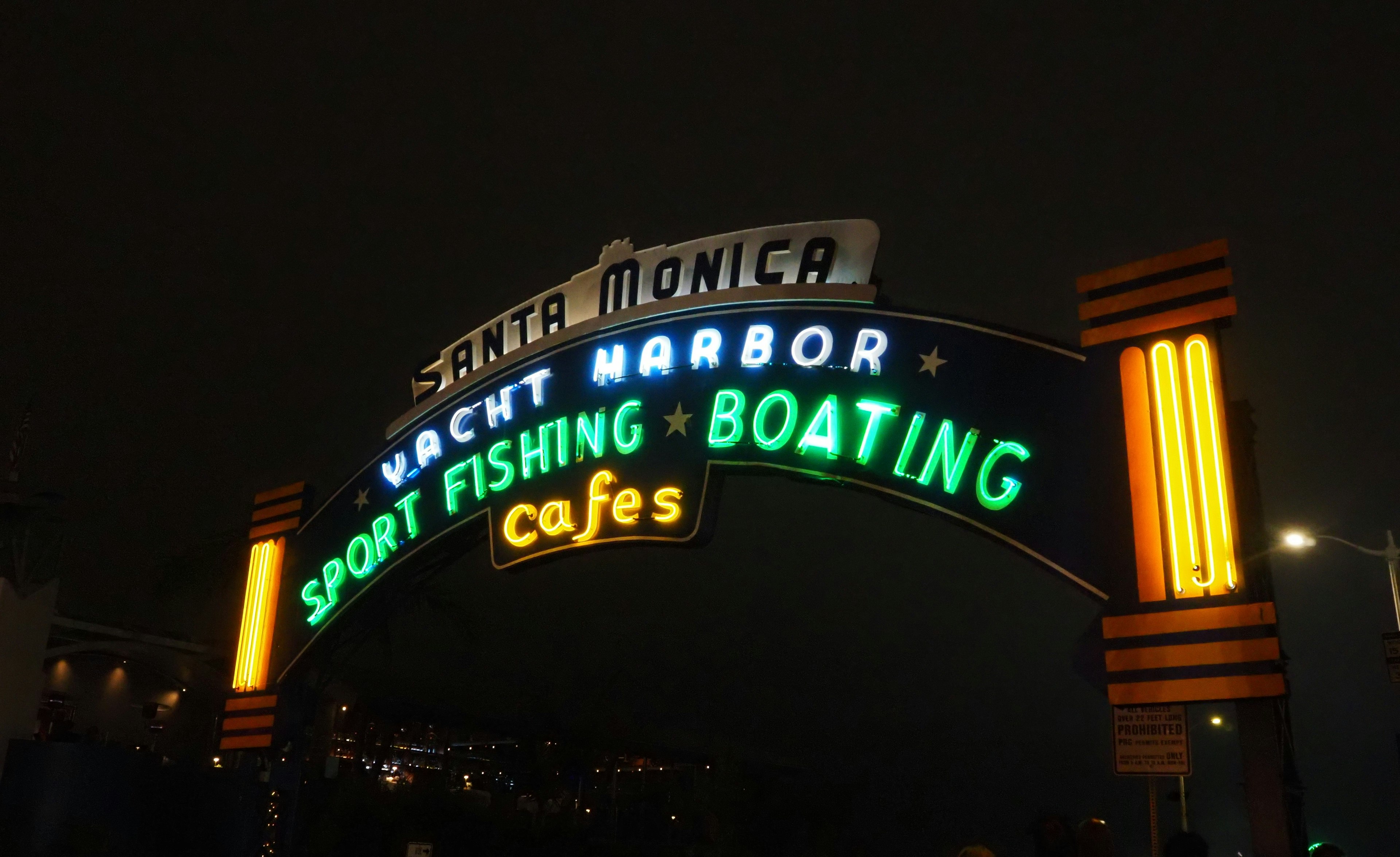 Cartel iluminado de Santa Monica que destaca la pesca deportiva y la navegación