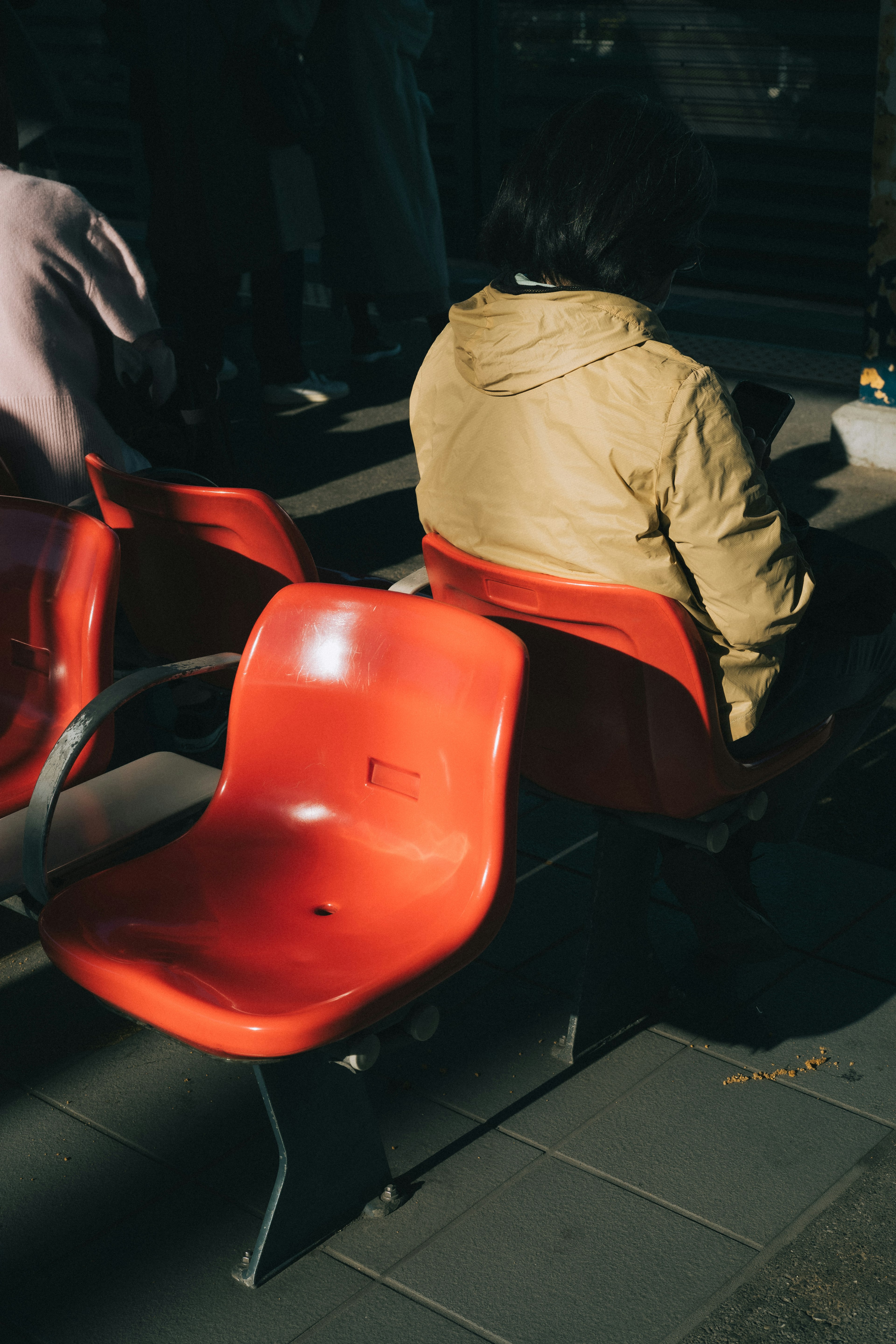 Una silla roja con una persona sentada detrás en ropa casual