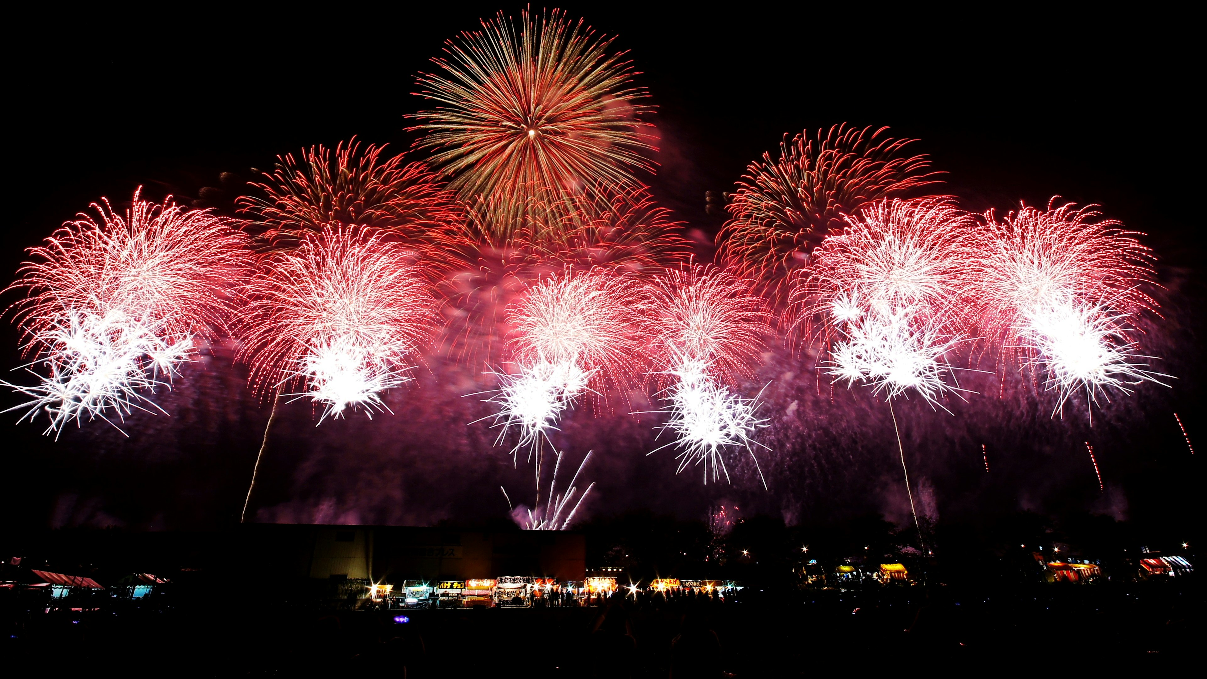 夜空に広がる赤と白の花火のショー