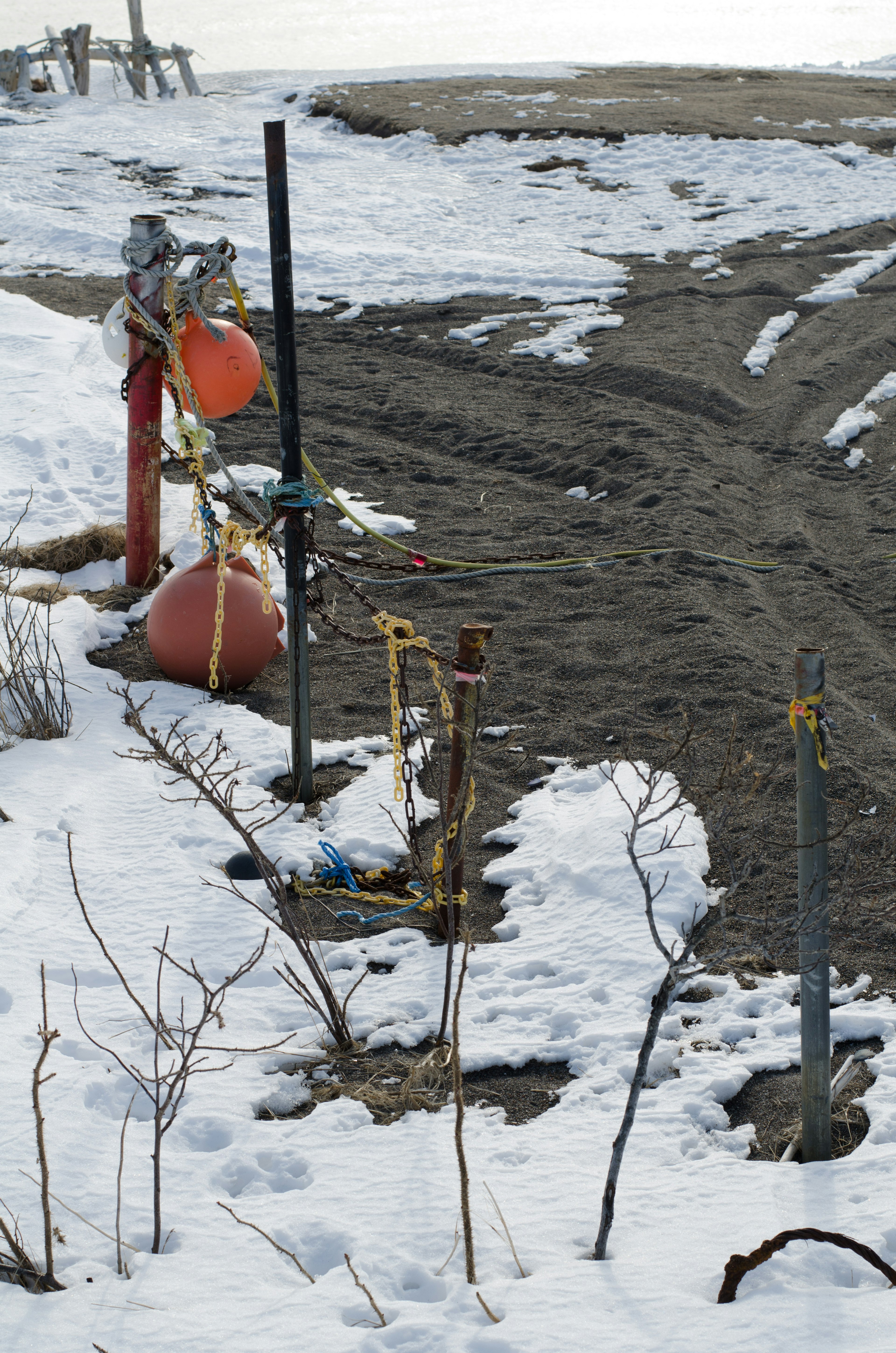 Baumaschinen und rote Bojen auf Schnee