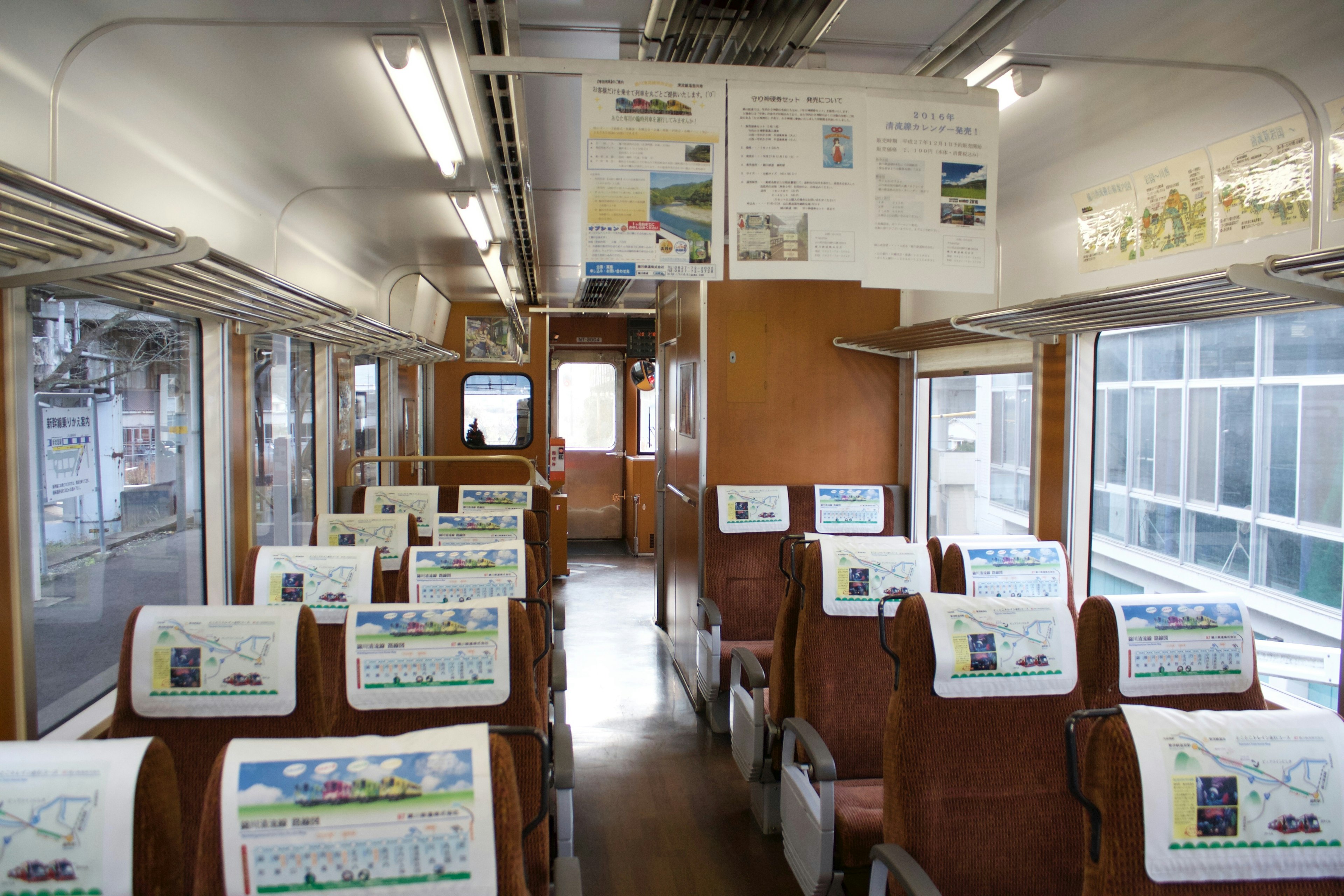 車両内部の座席と広告が見える列車の車両