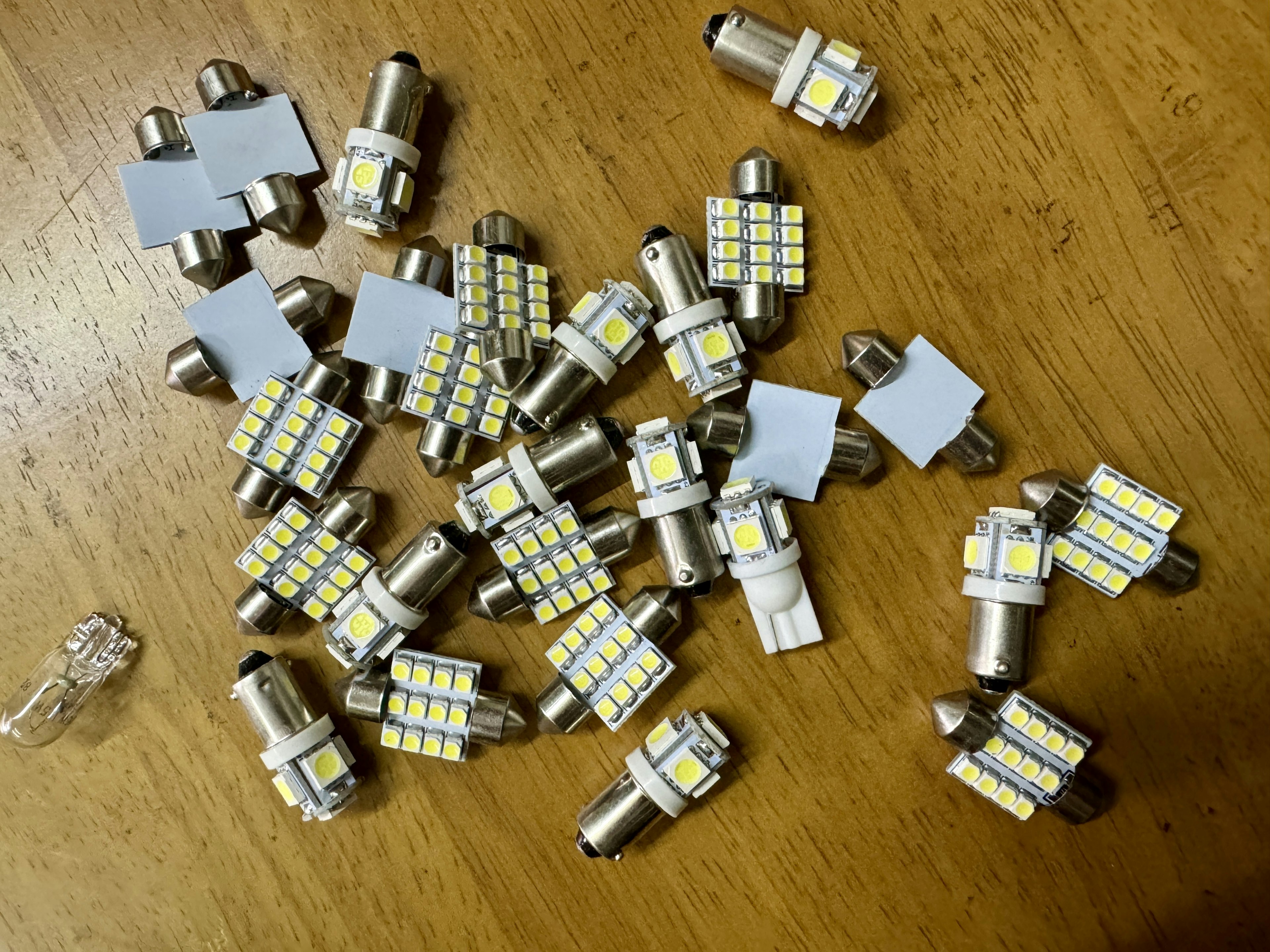 Numerous LED bulbs scattered on a wooden table