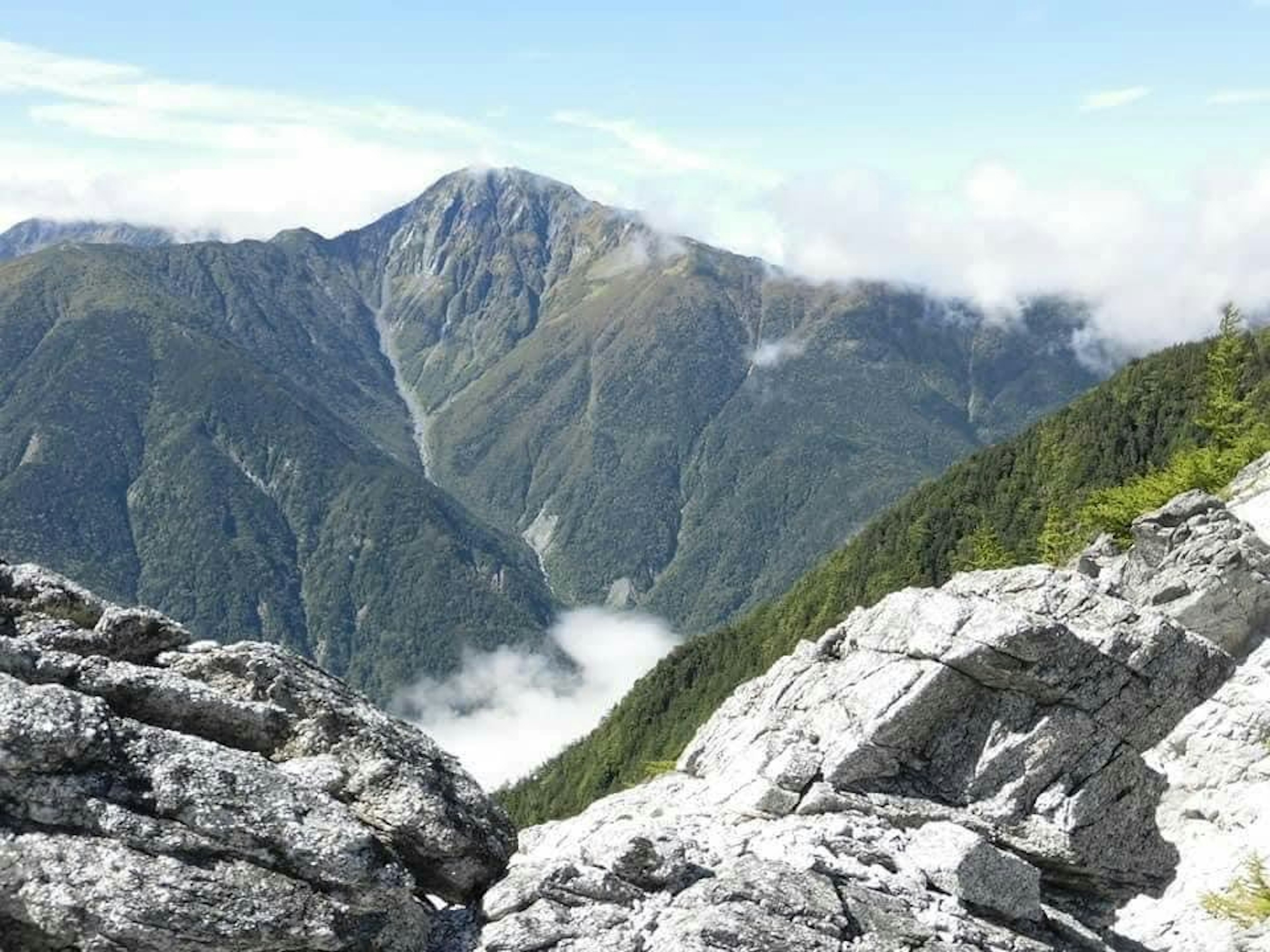 山の景色が広がり、雲がかかった山々が見える