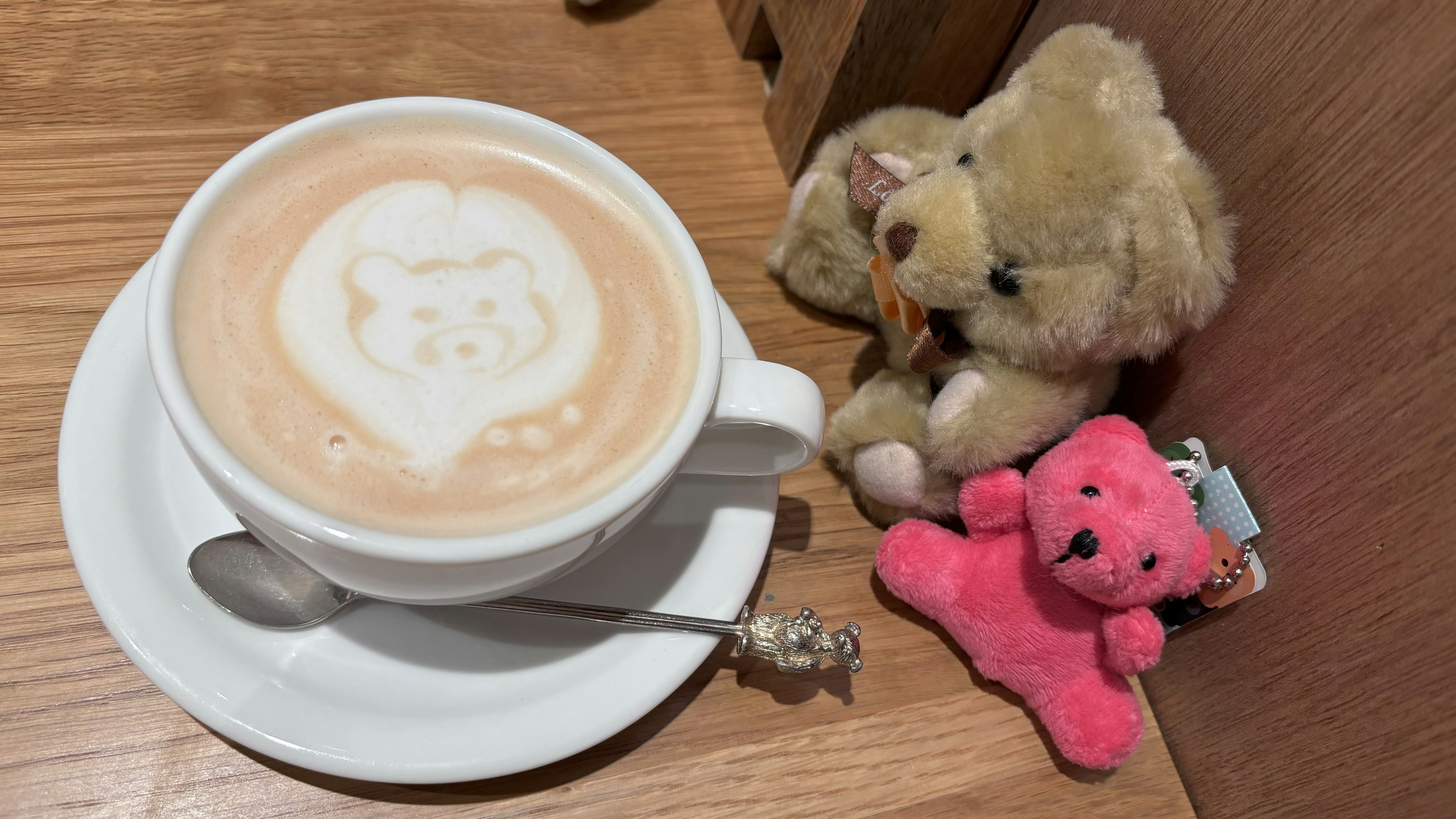 クマのラテアートとぬいぐるみのあるカフェのシーン