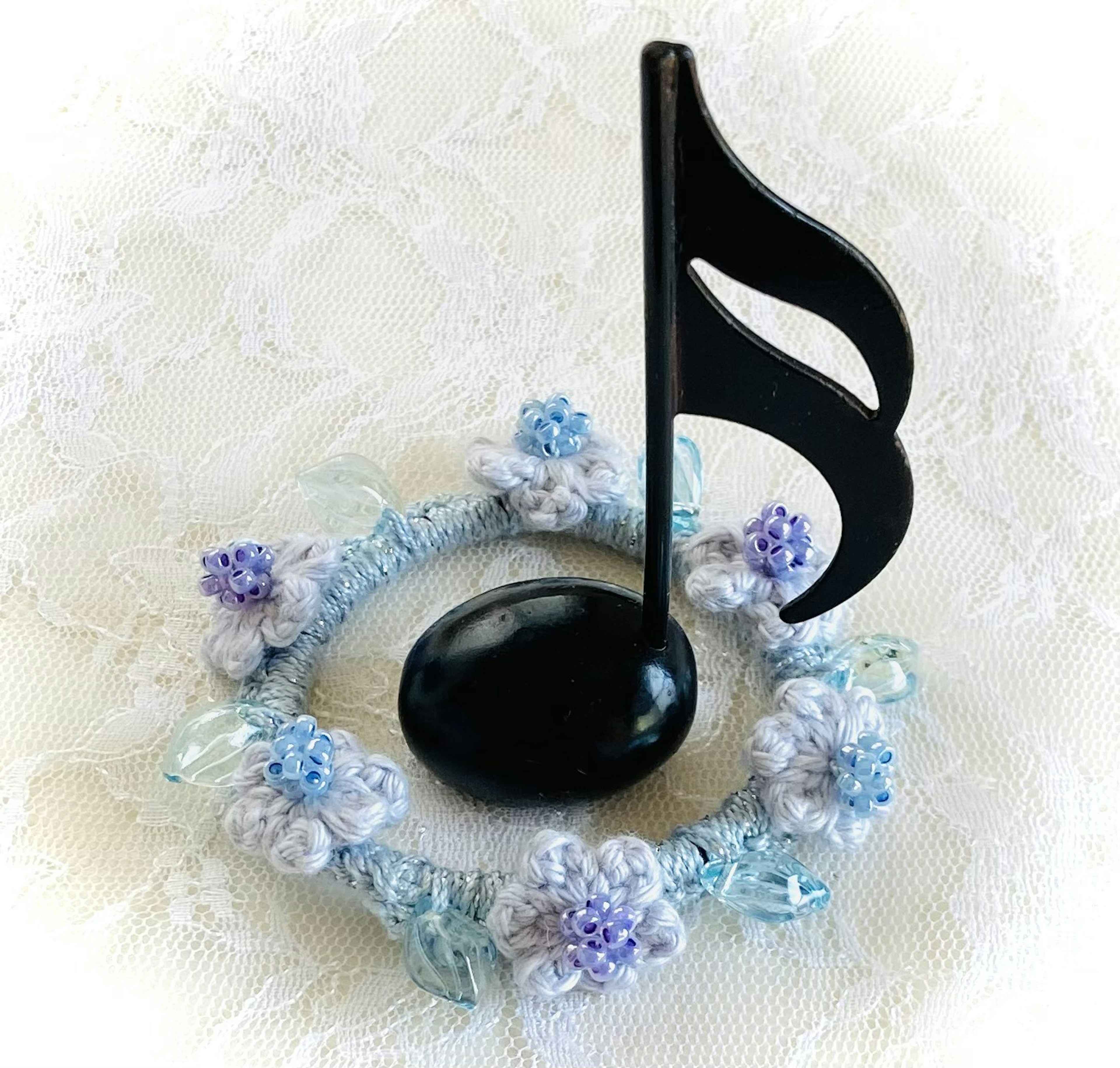 Nota musicale nera con decorazione floreale