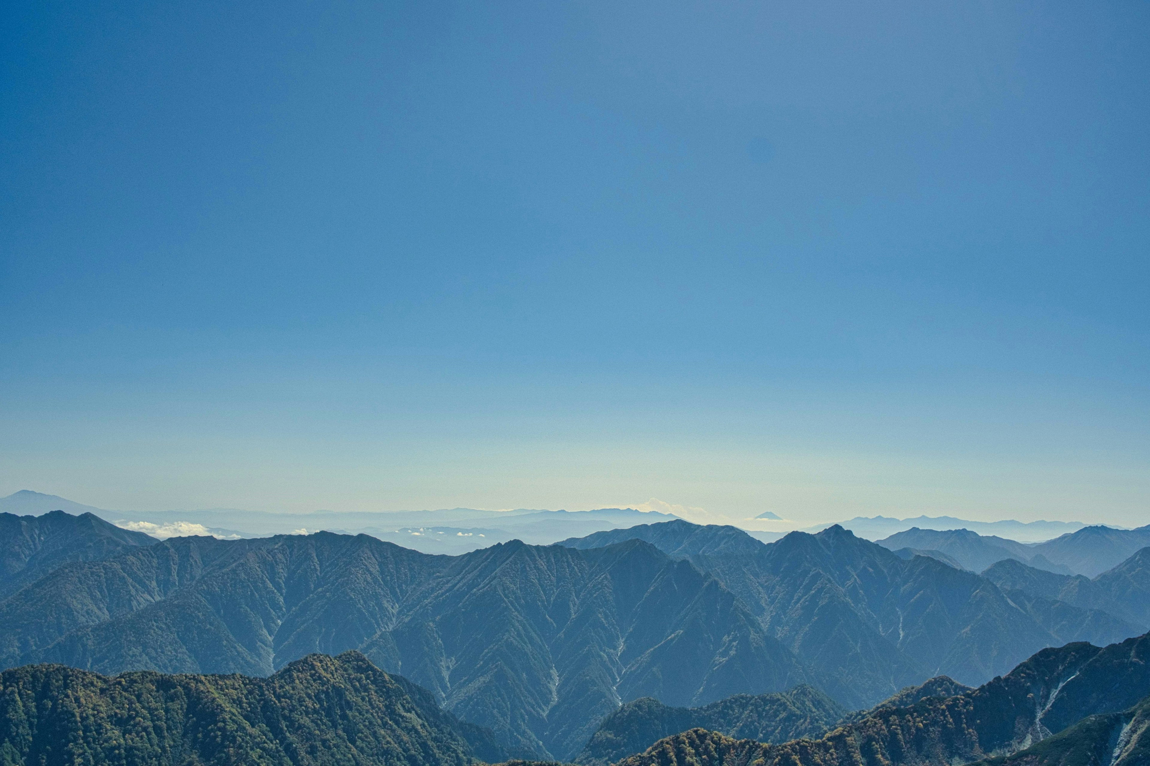 Pemandangan luas gunung di bawah langit biru cerah