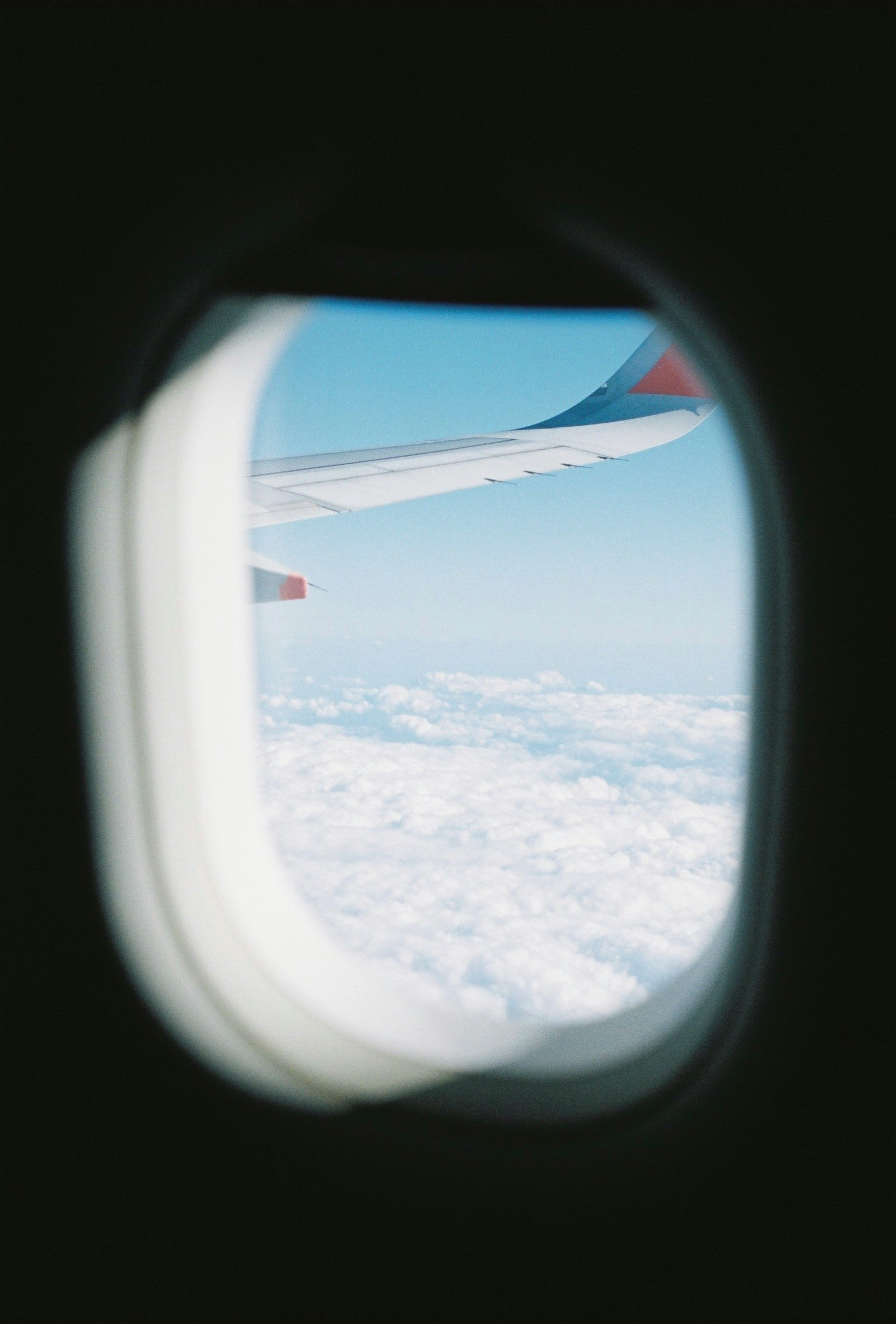 飛行機の窓からの青空と雲の景色