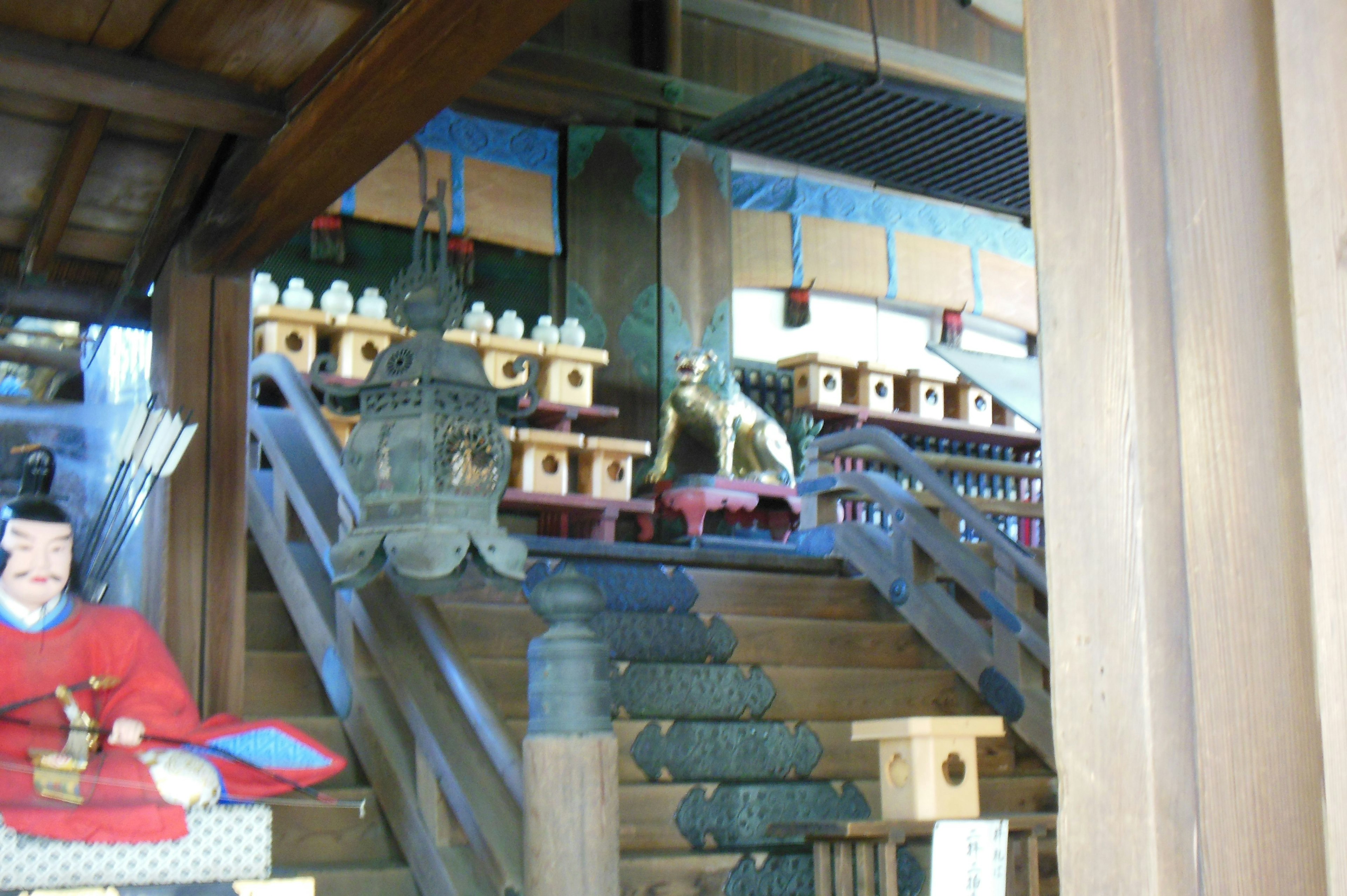 Stairs of a shrine with offering boxes and a statue of a dog