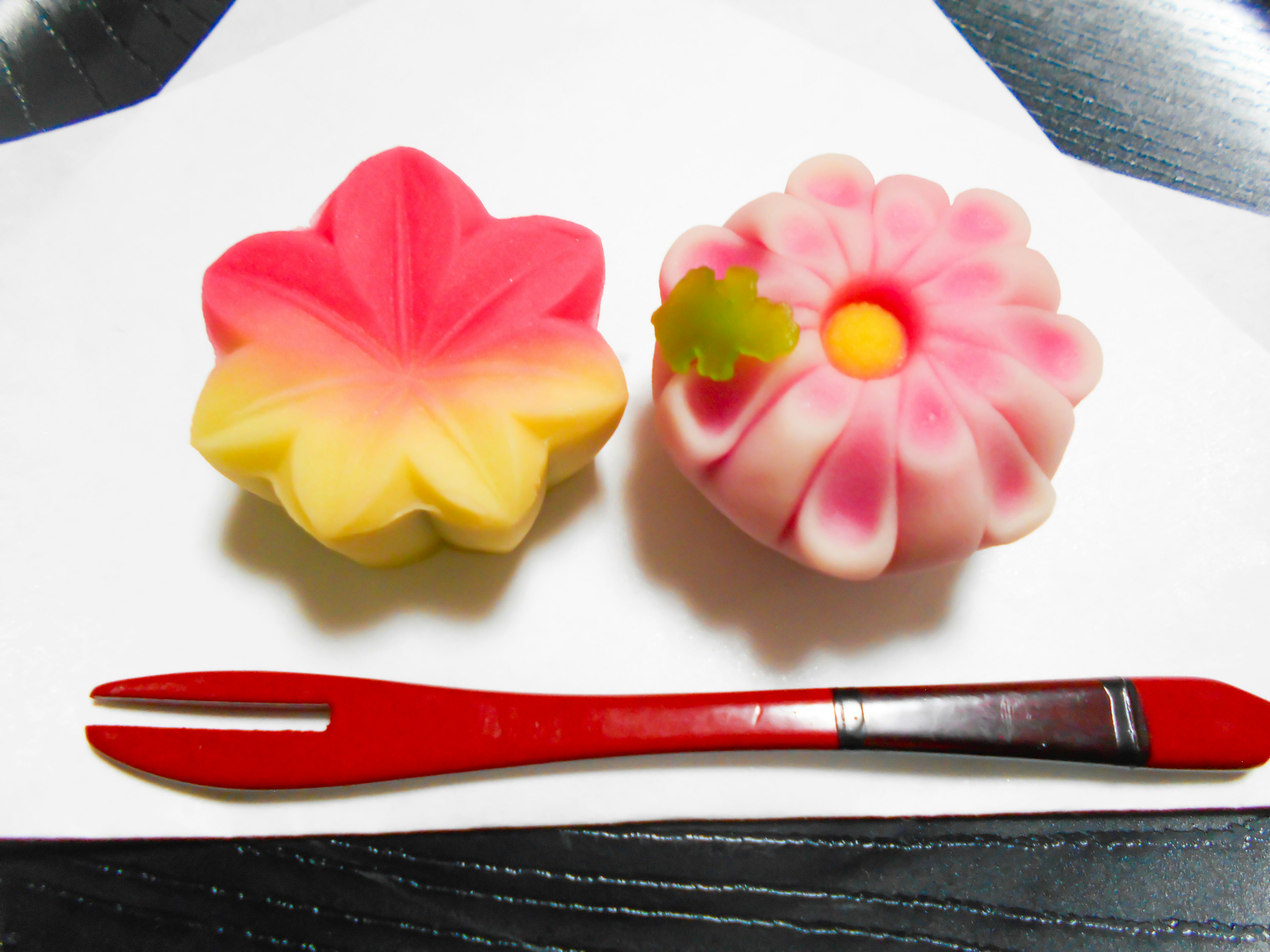 Beautiful Japanese sweets shaped like flowers and leaves with a red fork