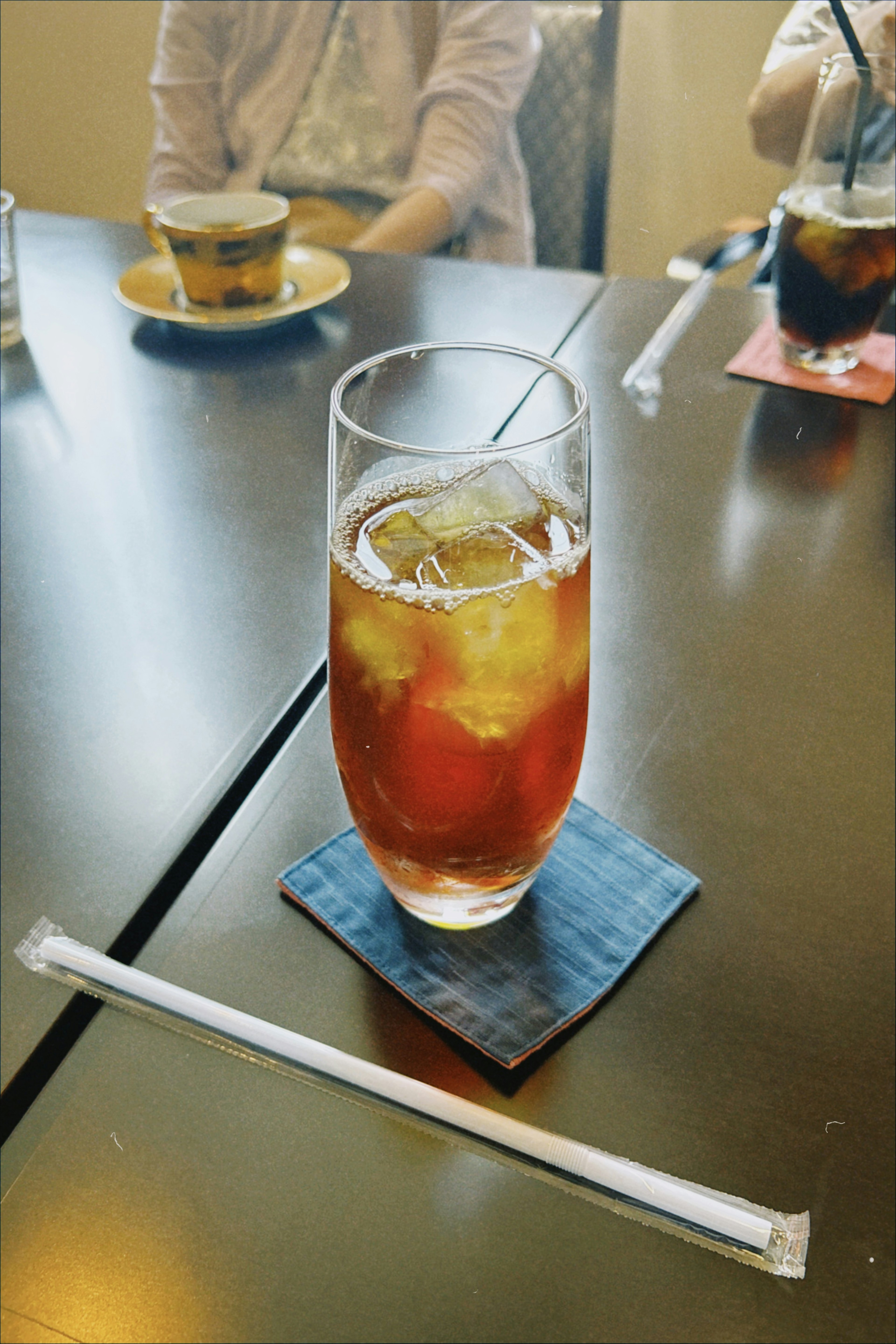 Glass of iced tea on a table with a coaster