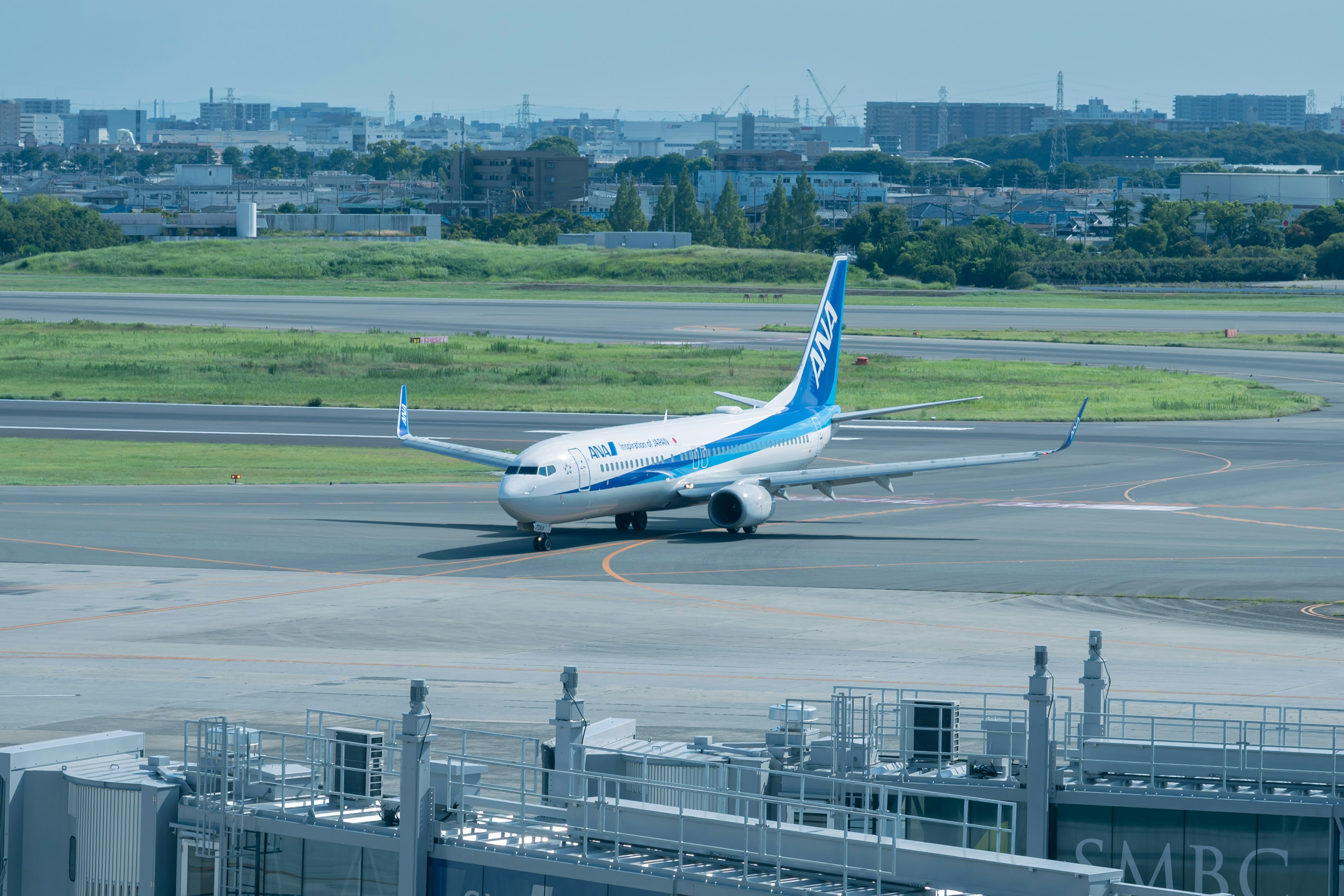 Un avión con una cola azul está rodando por la pista