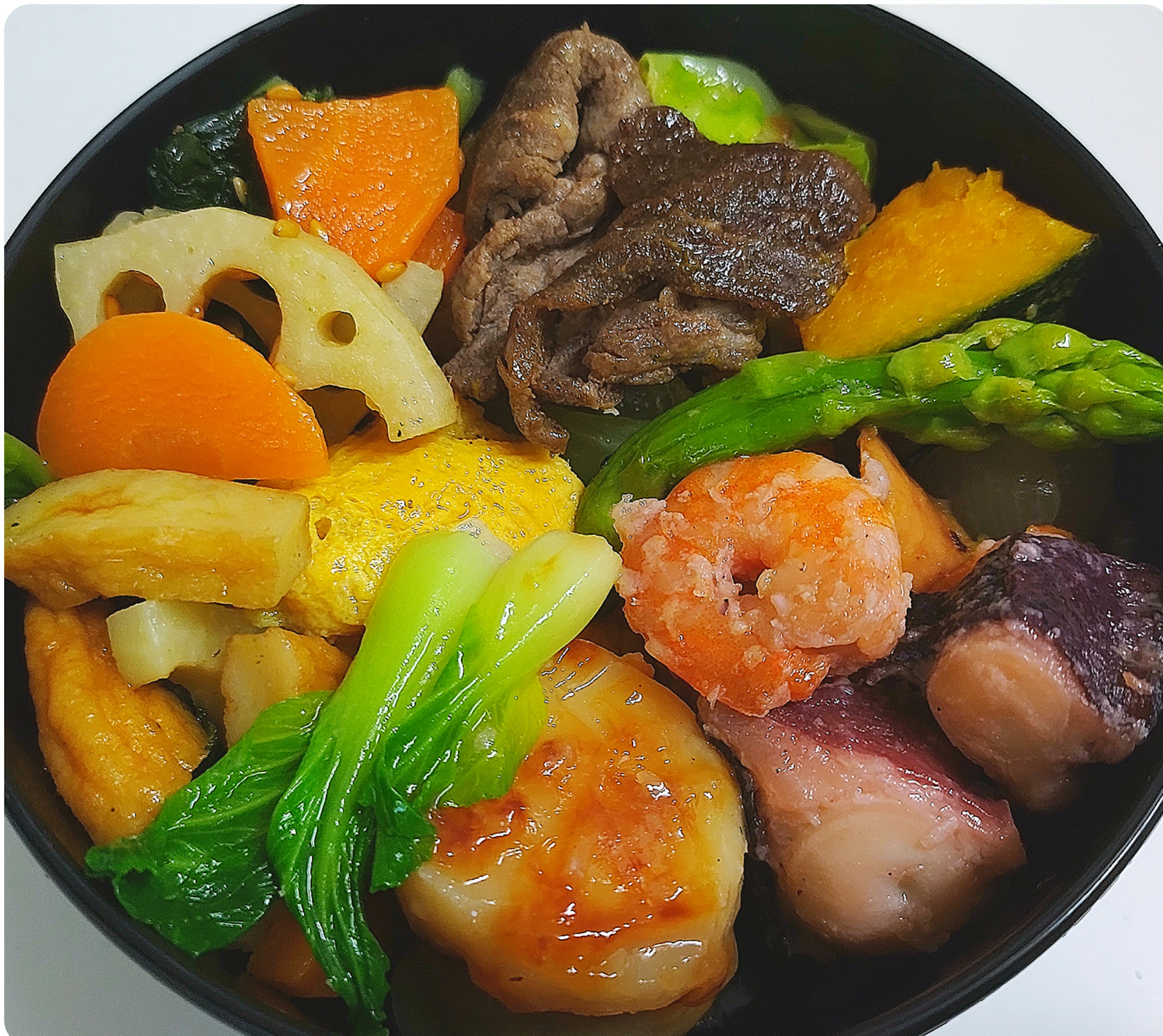 Assortiment coloré de légumes et de fruits de mer dans un plat japonais traditionnel